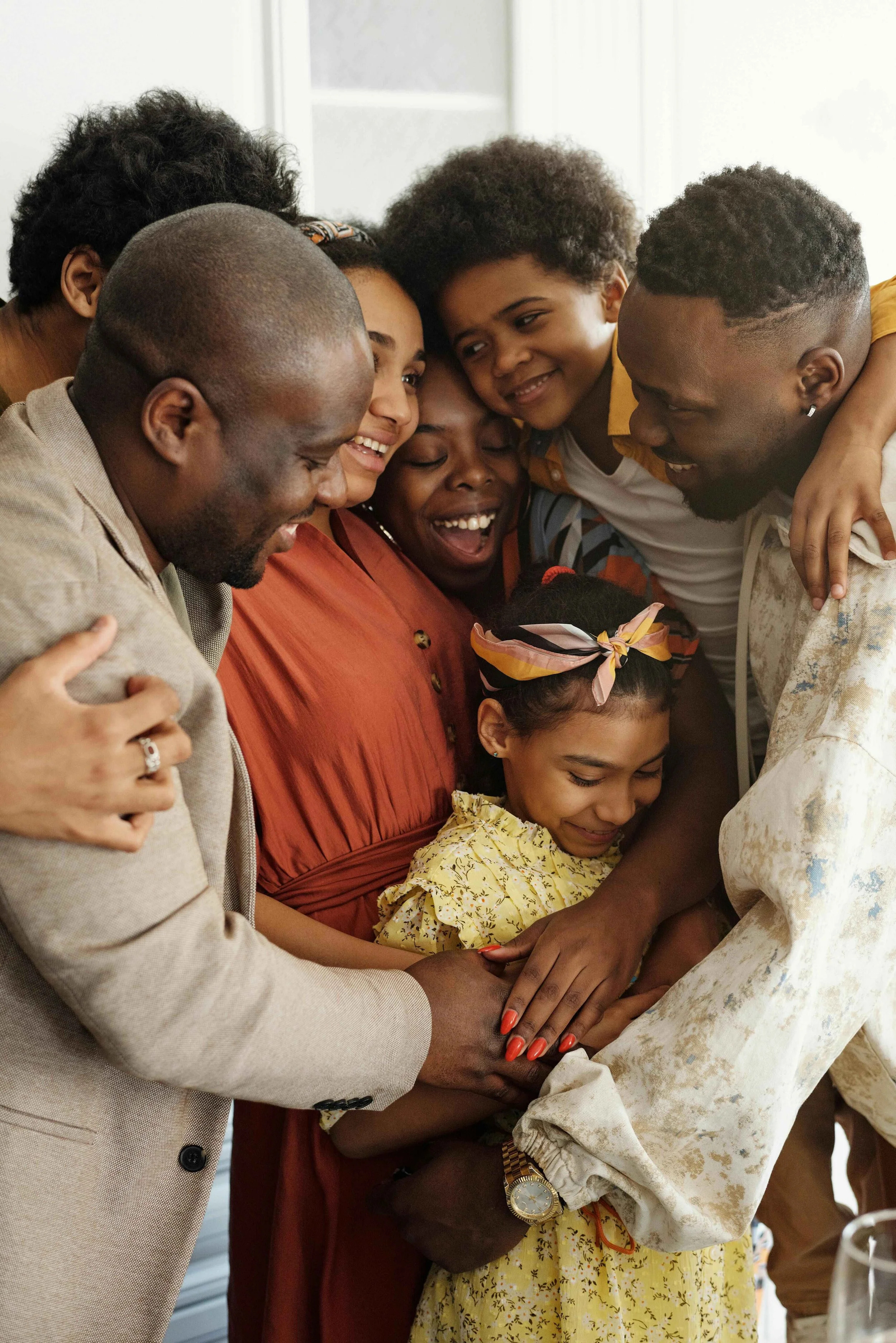 Family of parents and siblings embracing together in a group hug, Hoboken NJ family therapy