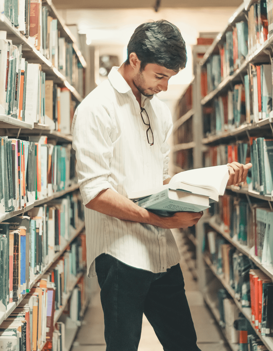 A college student studying in a university library, supported by therapy for college students at Anchor Therapy.