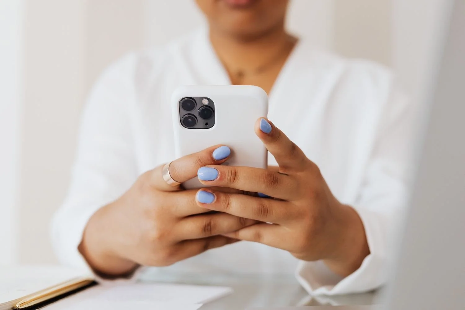 Woman holding her phone with both hands while scrolling back through it, false memory OCD Hoboken NJ therapist
