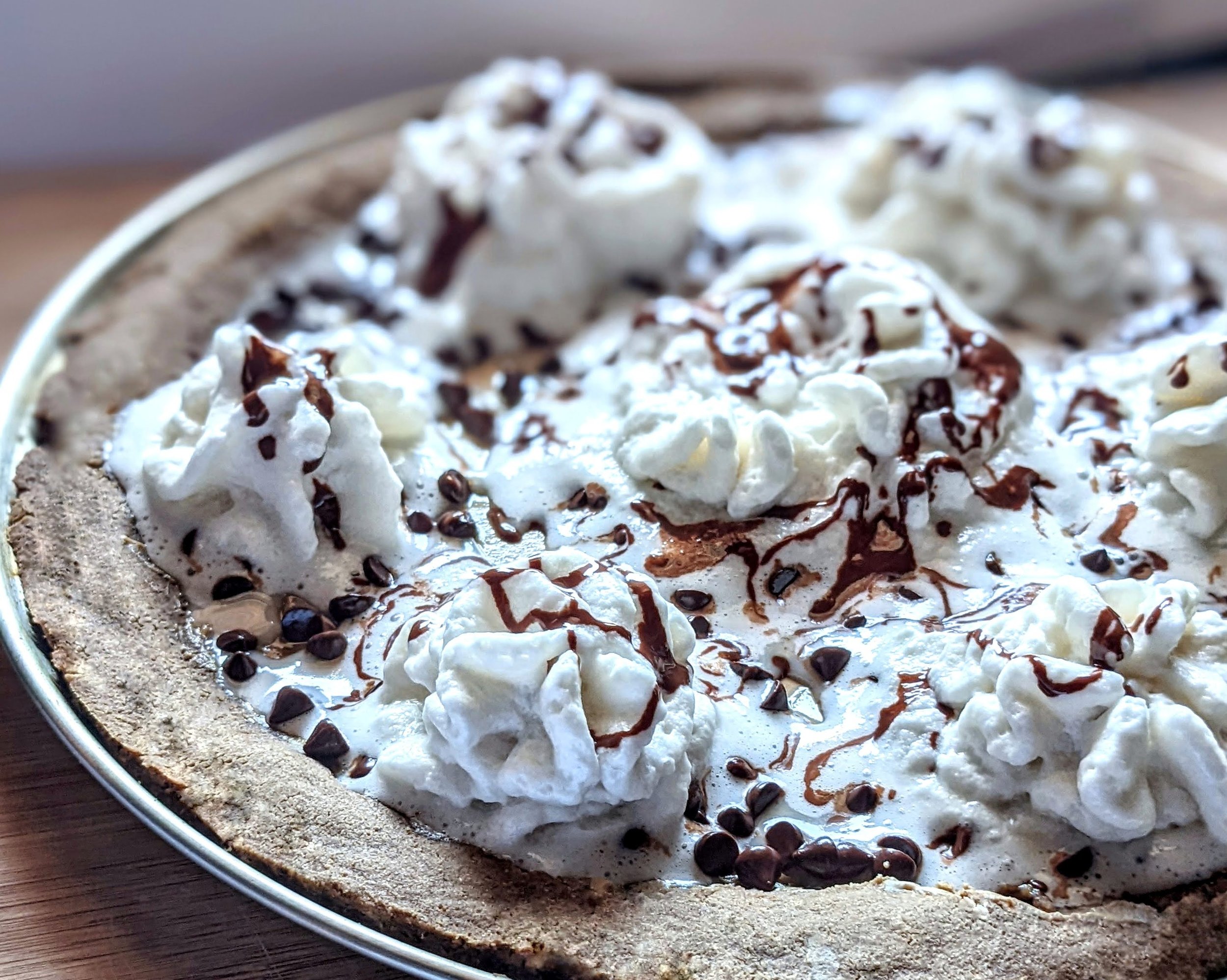 Bare Life Hot Chocolate Pizza Dough sunfun butter & choco chips whipped cream close up side.jpeg