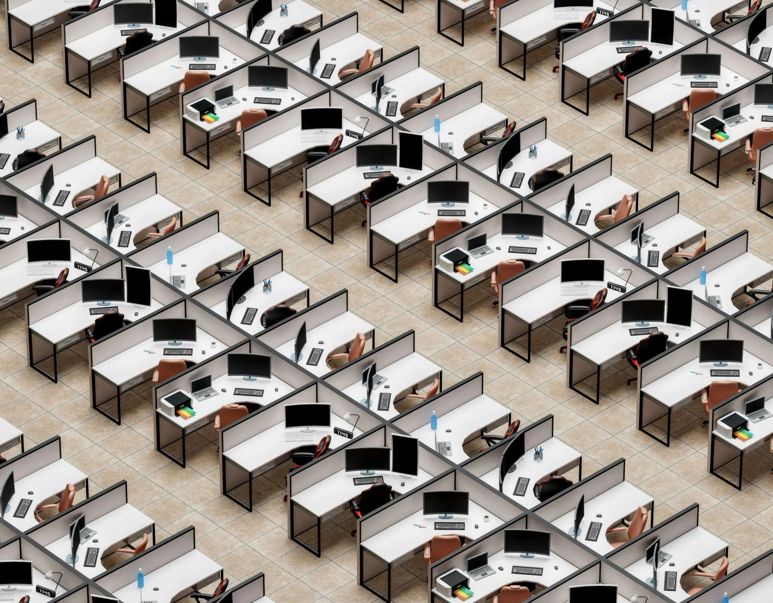 Rows of office cubicles with desks, computer monitors and chairs arranged in a grid inside a corporate workplace.