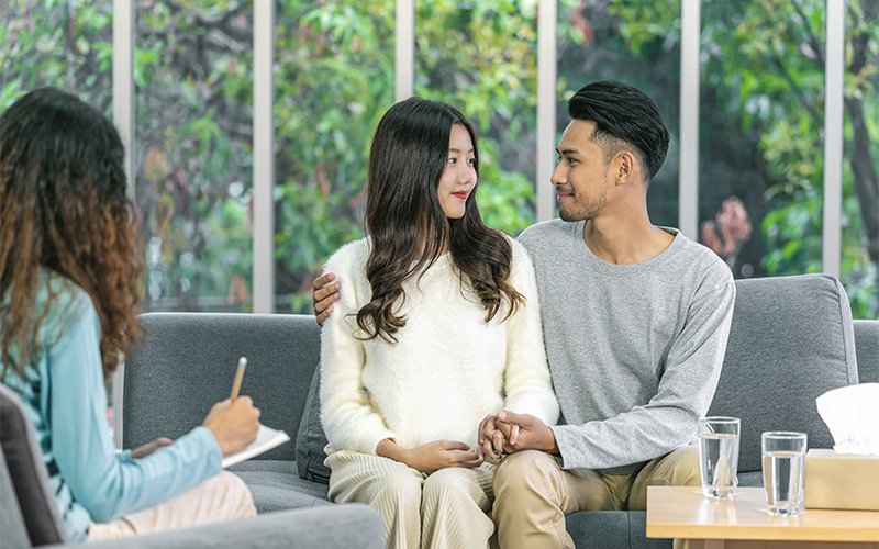 Couple holding hands during a relationship counseling session.
