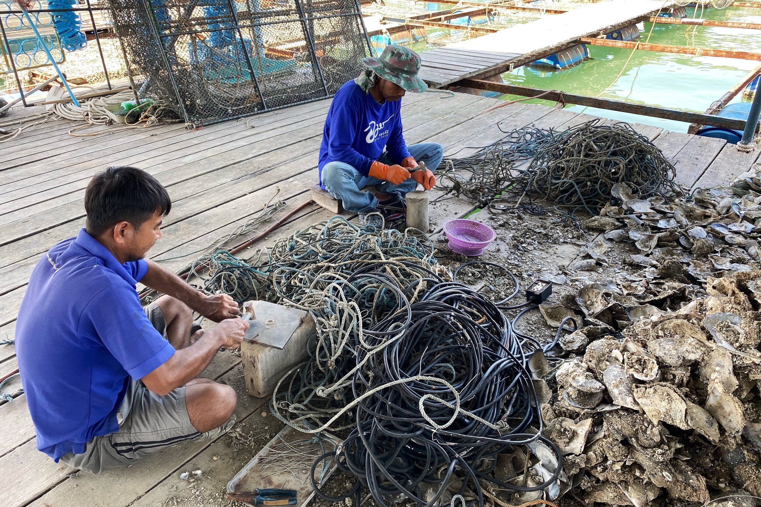 Phuket Pearl employees hard at work in creating the metal spokes for which they tie the oysters.