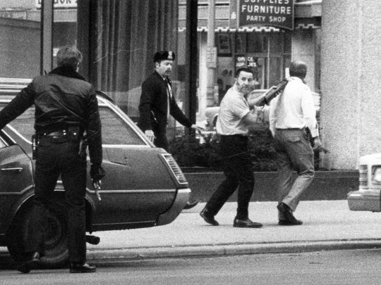 Tony marching Richard throughout town at gunpoint.