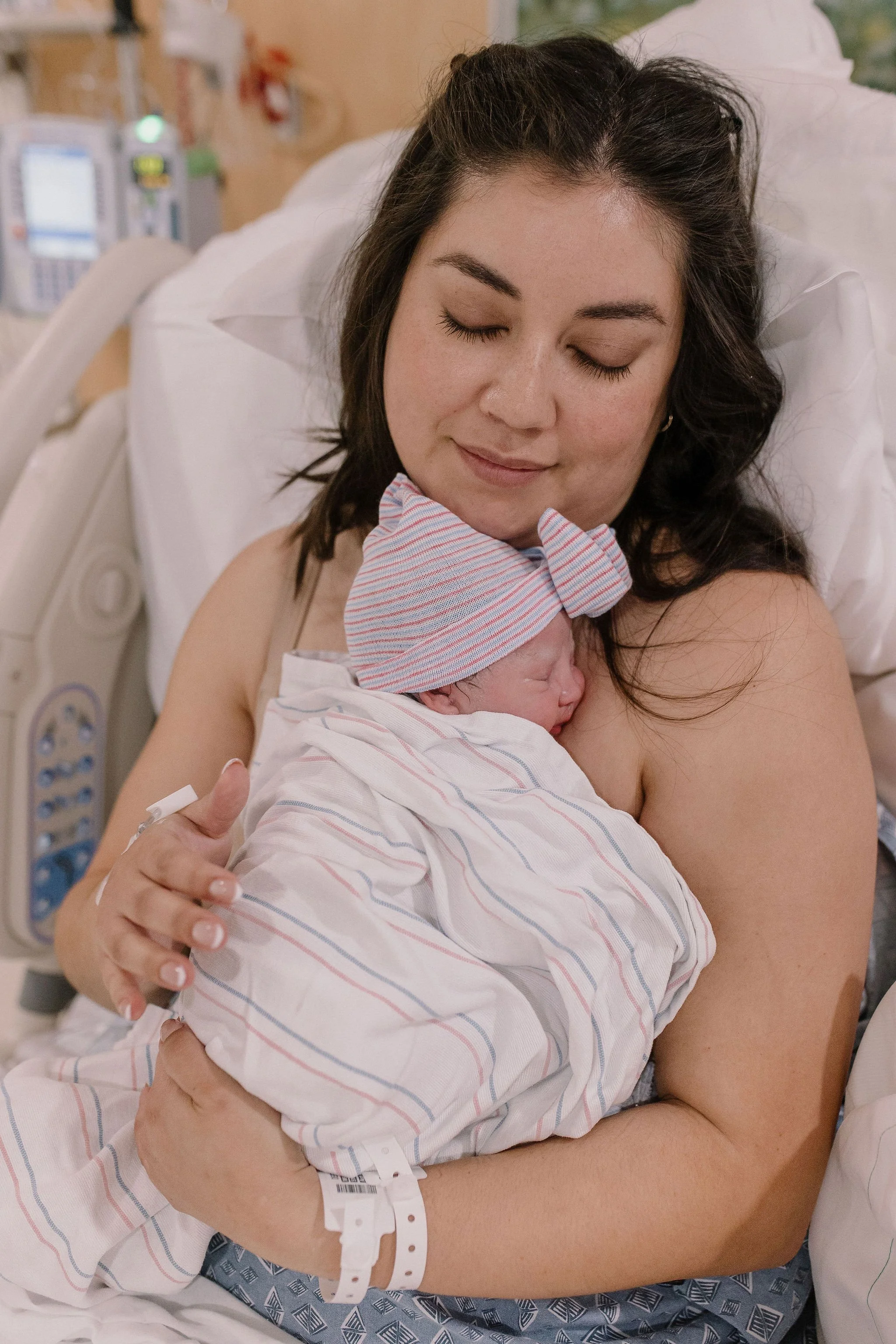 mom holding newborn baby in golden hour birth photography session