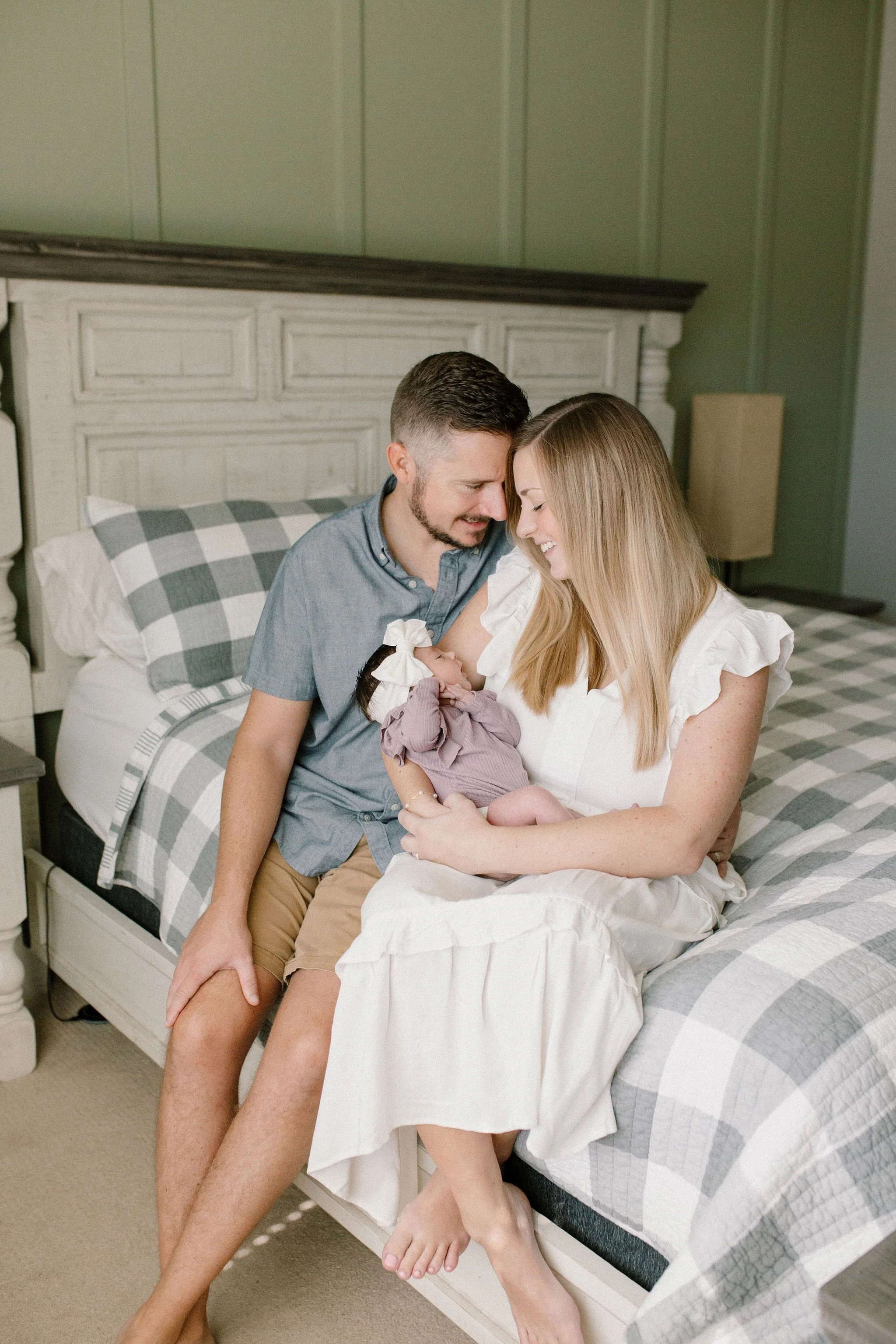 mom and dad holding baby in primary bedroom captured by Mesa newborn photographer