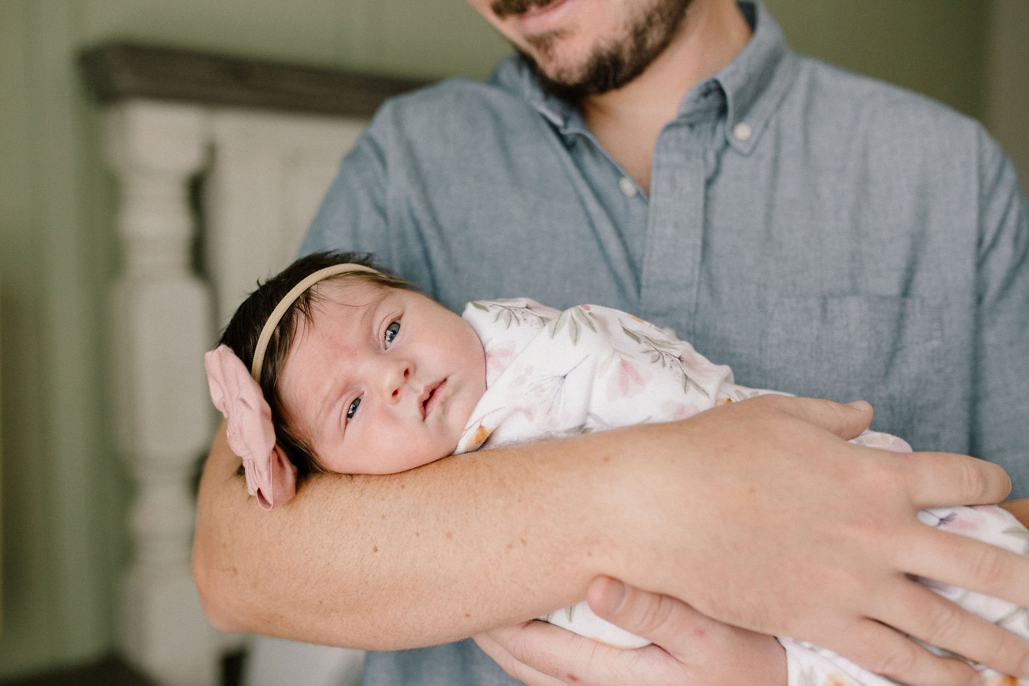 dad holding baby girl in window light by Mesa newborn photographer