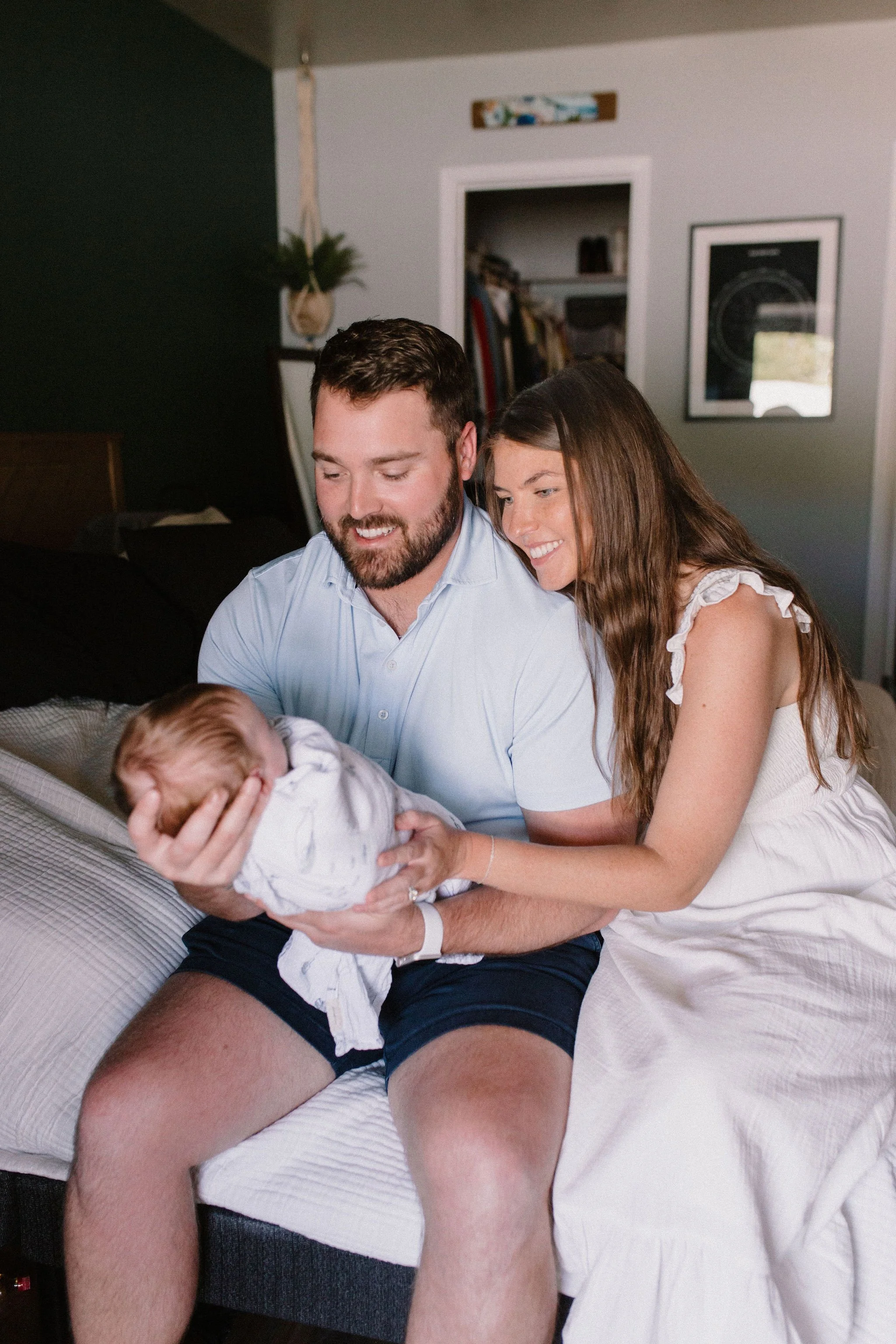mom and dad holding baby in primary bedroom captured by Tempe Arizona newborn photographer