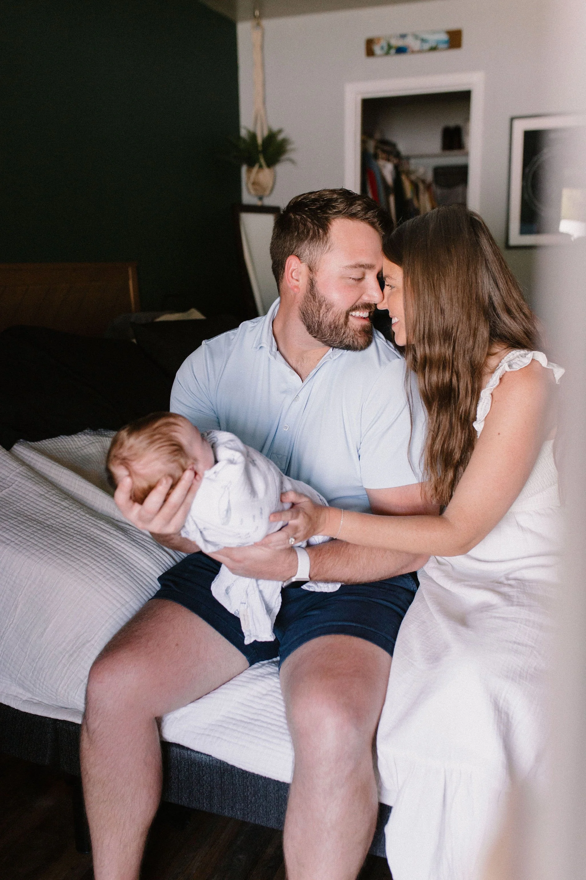 mom and dad holding baby in primary bedroom captured by Tempe Arizona newborn photographer