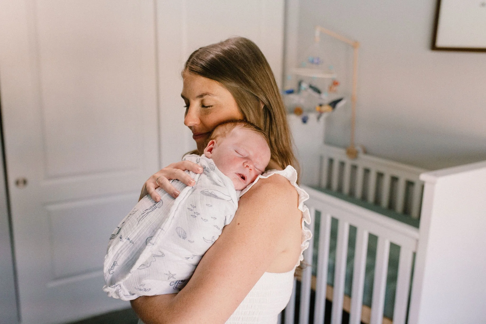 mom holding baby sleeping on her shoulder taken by Tempe Arizona newborn photographer