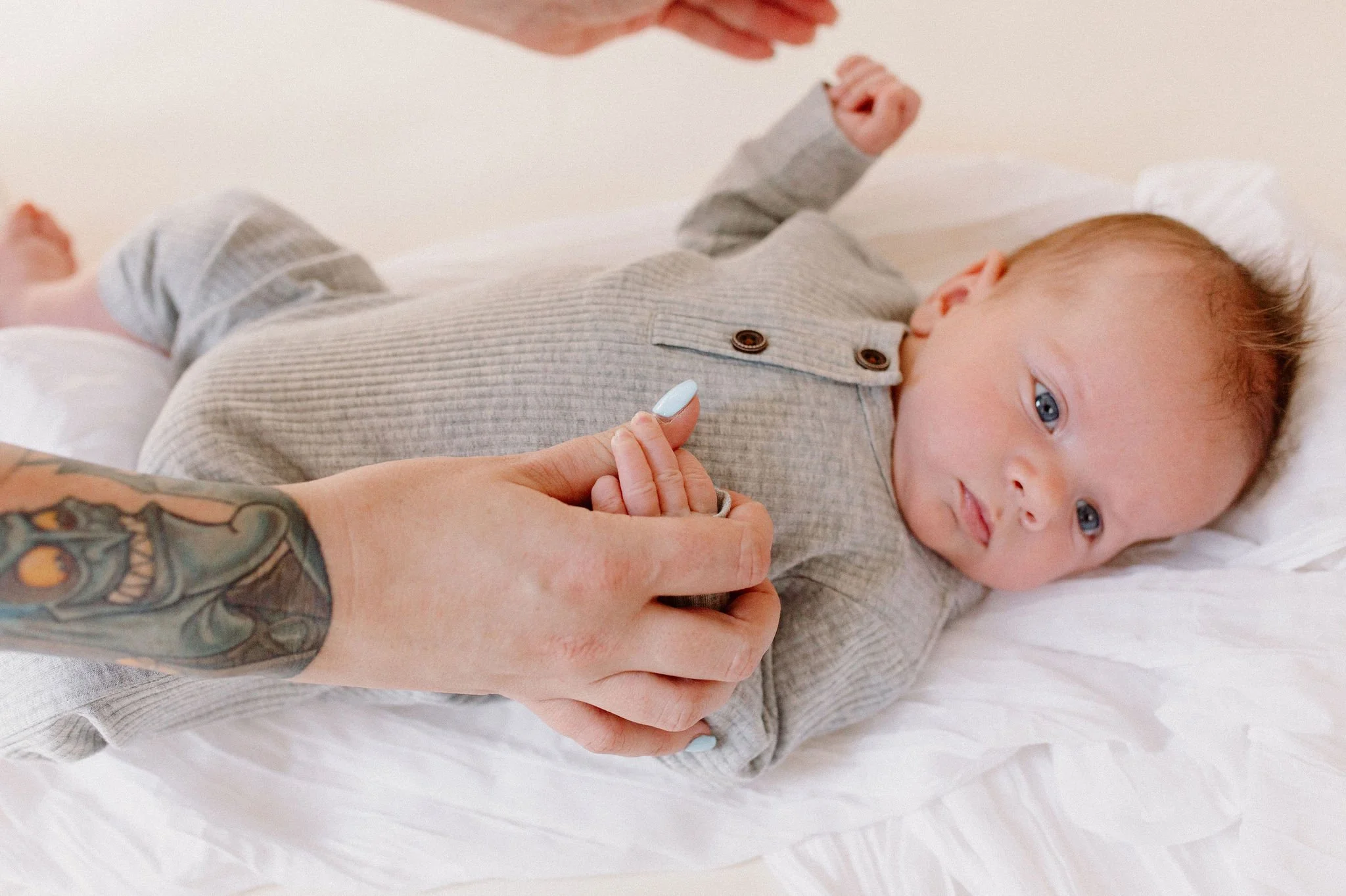 mom holding baby hand close-up detail shot in natural light studio by Phoenix newborn photographer