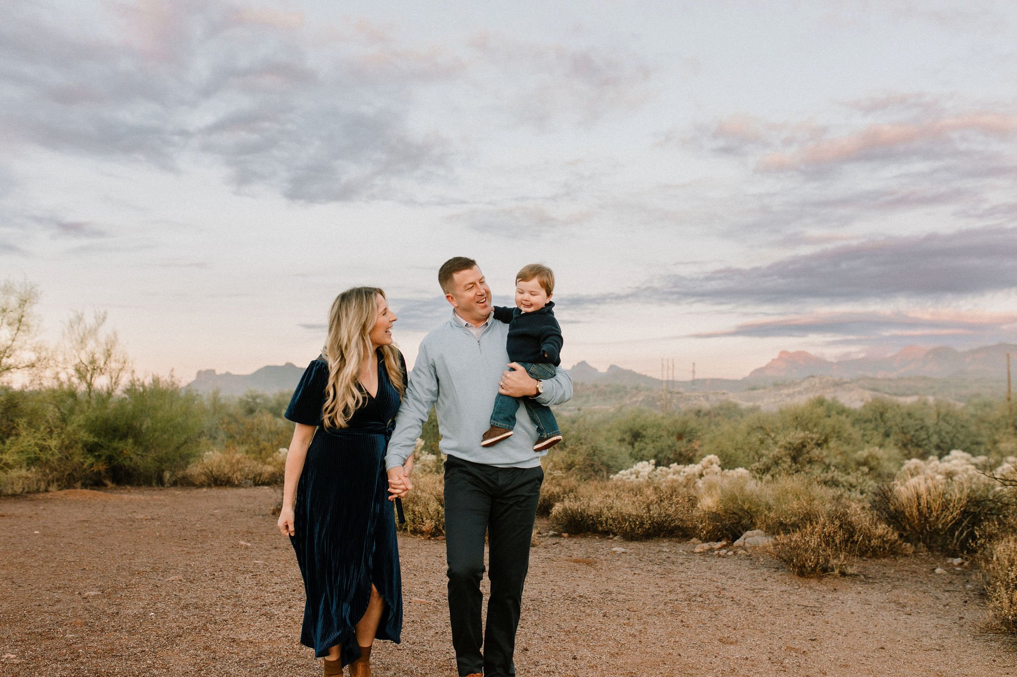 family of three walking in the desert during blue hour