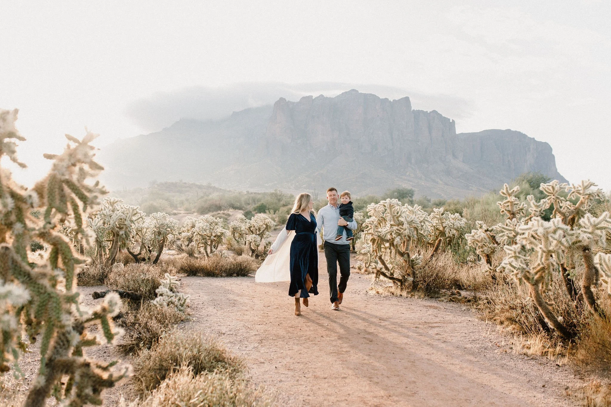 family of three walking in the desert during misty morning photography session at Superstition Mountains