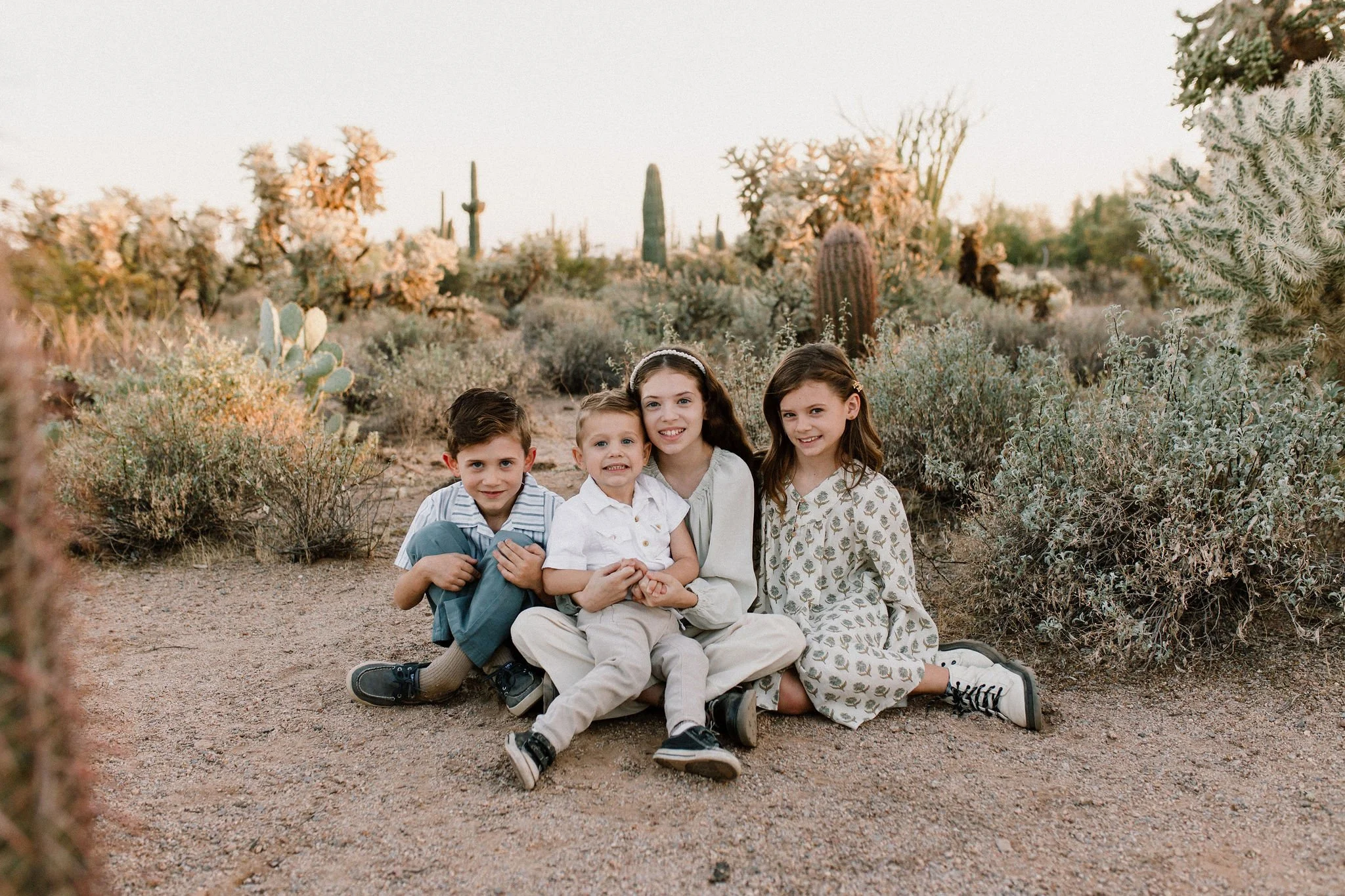 siblings sitting in the desert captured by Mesa family photographer
