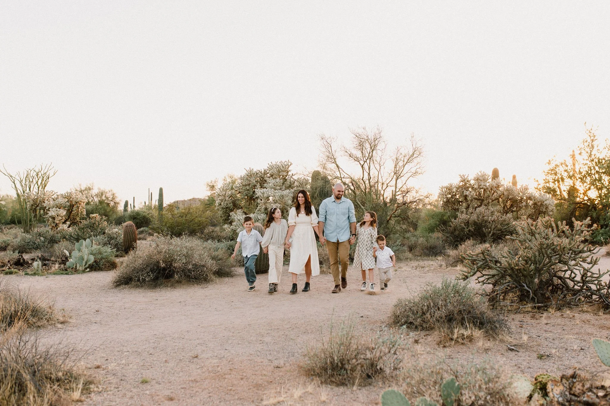 family walking and holding hands captured by Mesa family photographer in Arizona desert