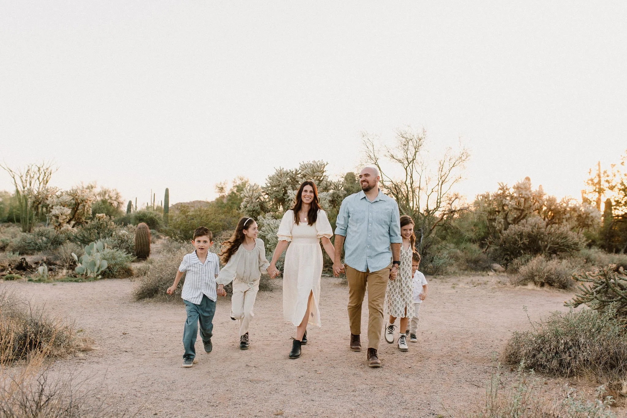 family walking and holding hands taken by Mesa family photographer in Arizona desert