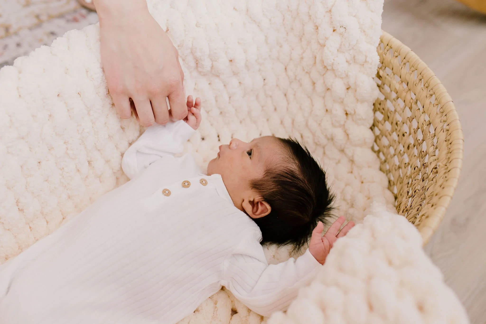 baby holding mom's finger in studio newborn photography session
