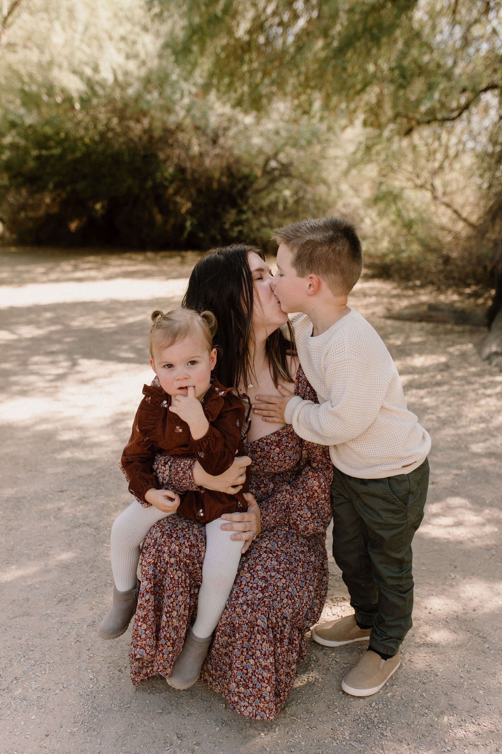 mom holding toddler girl and kissing toddler boy captured by Gilbert Arizona family photographer