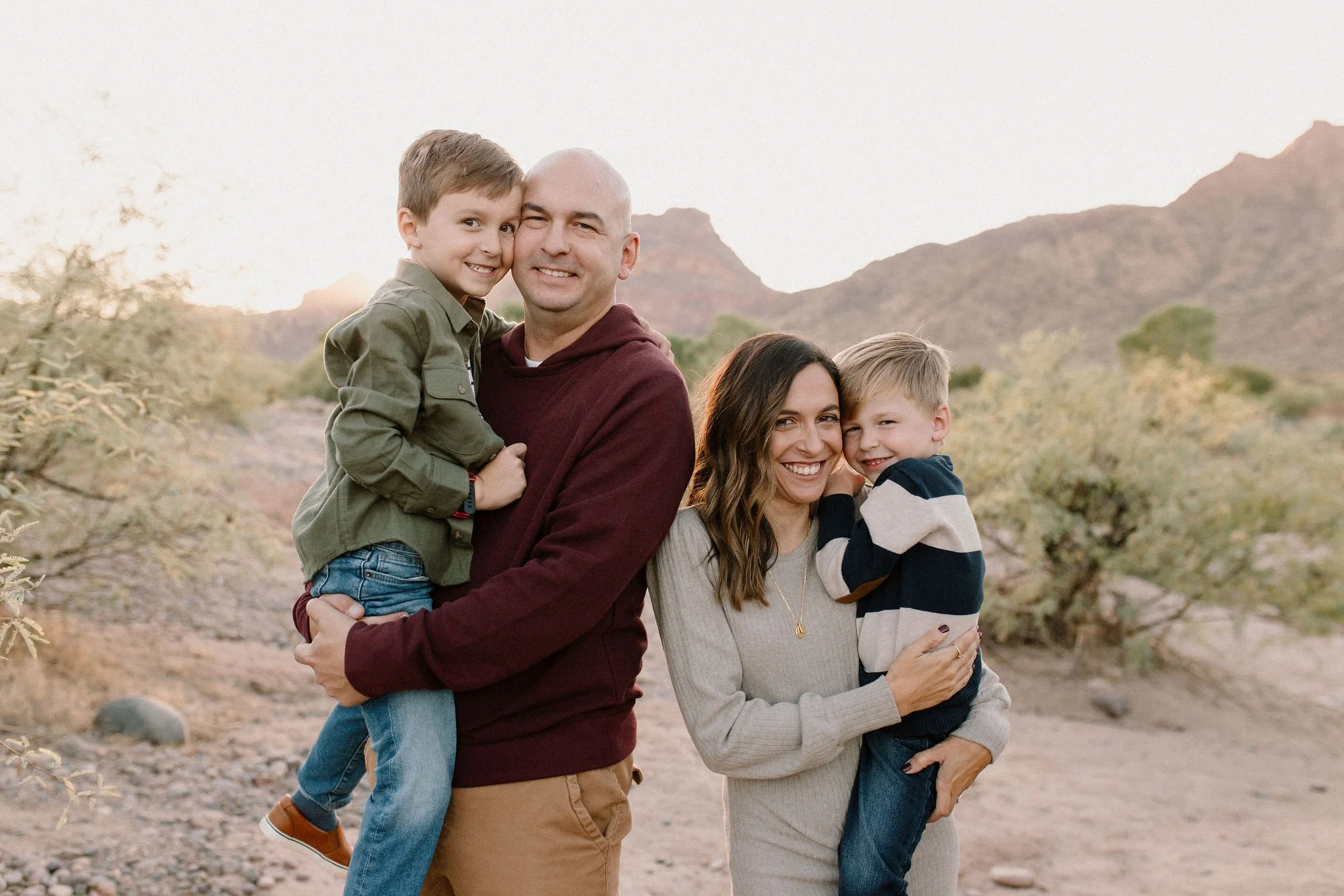 mom and dad holding little boys smiling in the desert at the Salt River in Arizona
