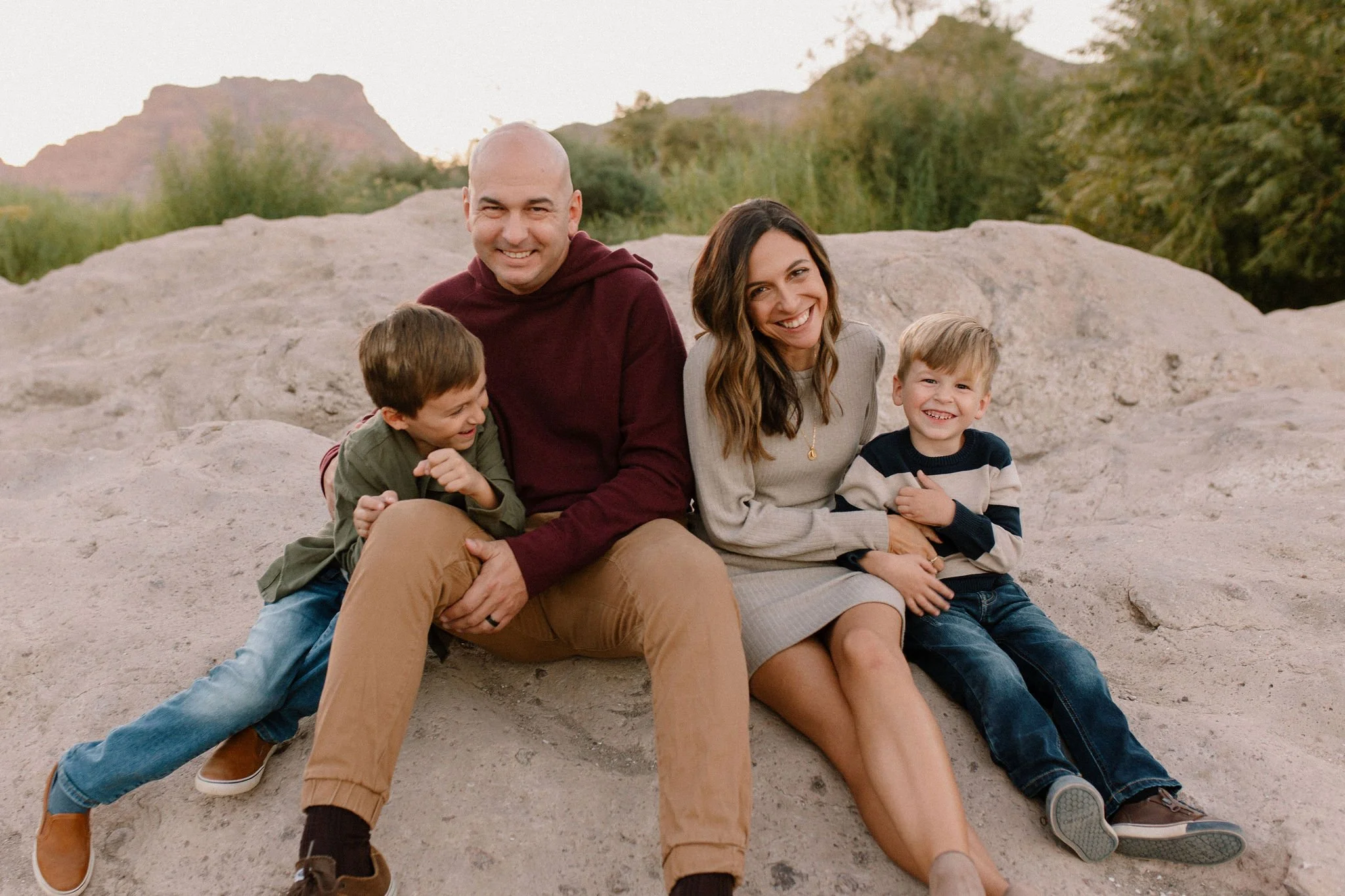 family sitting together on pink rocks by the Salt River in Arizona
