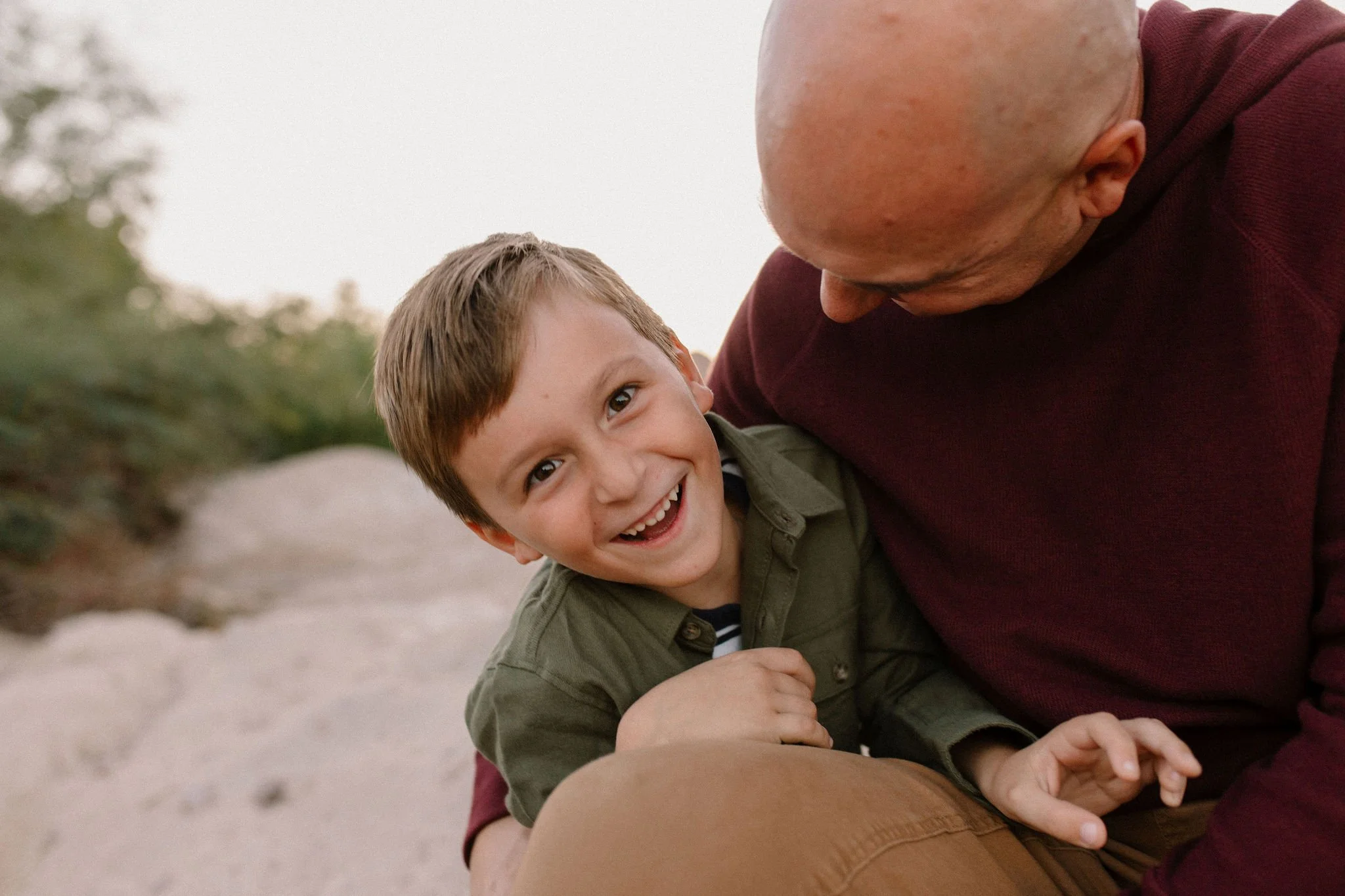 dad tickling son laughing by the Salt River in Arizona