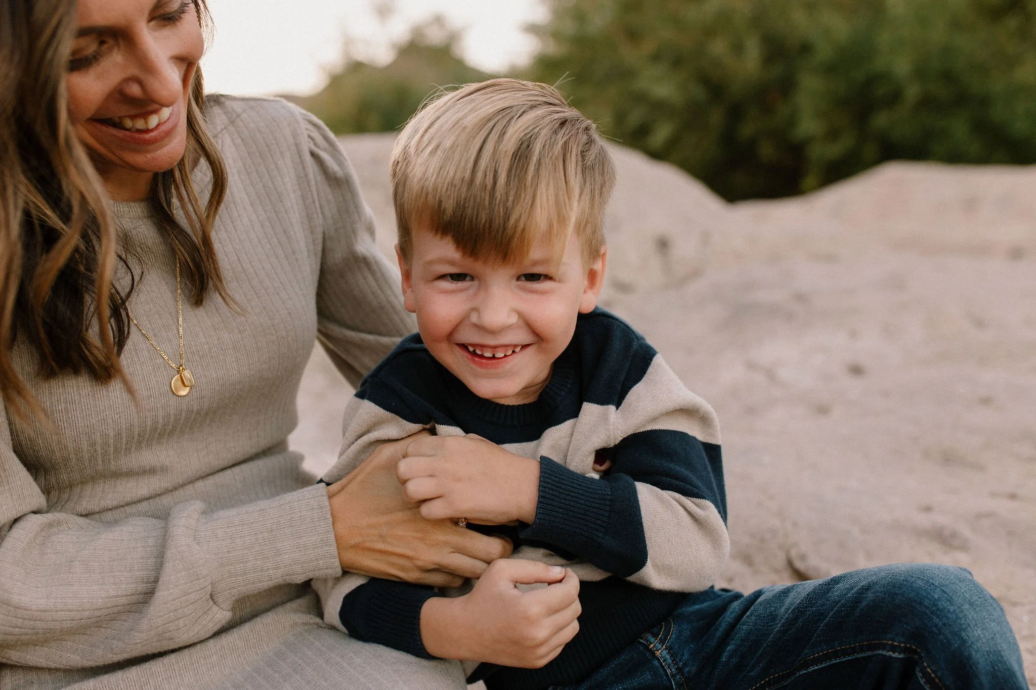 mom tickling son laughing by Salt River in Arizona