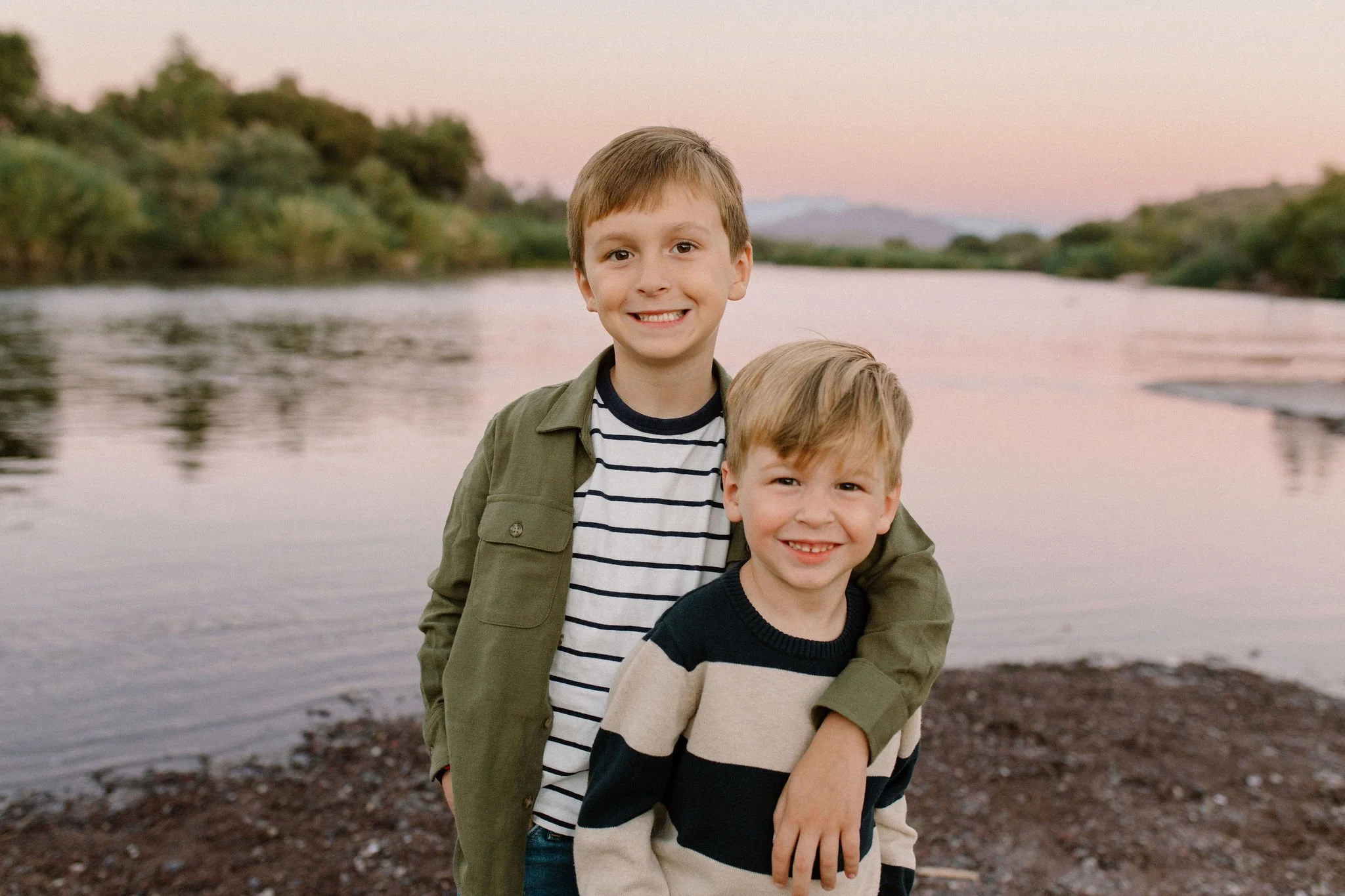 brothers standing together smiling by the Salt River at blue hour in Arizona