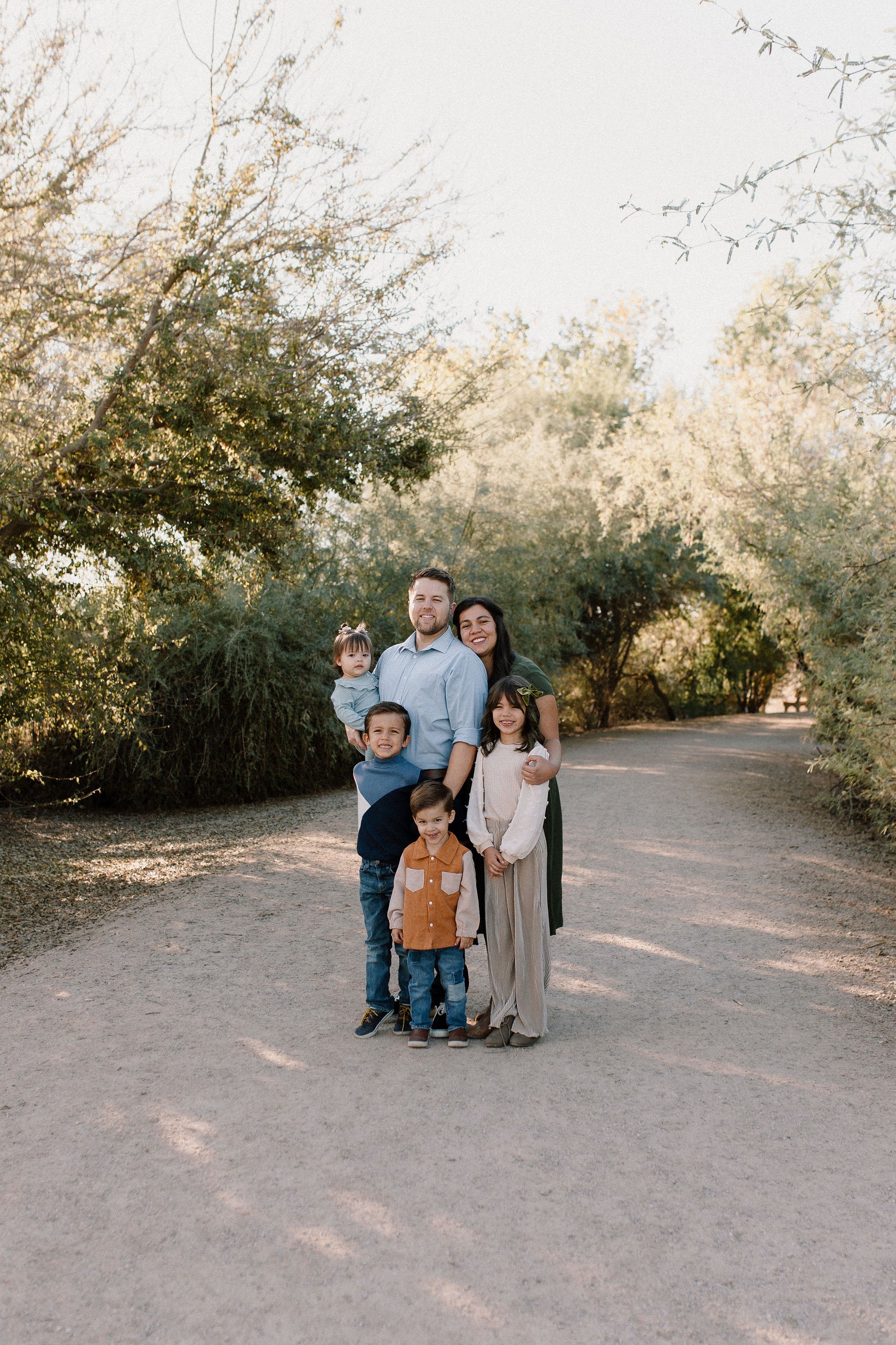 family of six standing together smiling in desert greenery extended family photography session
