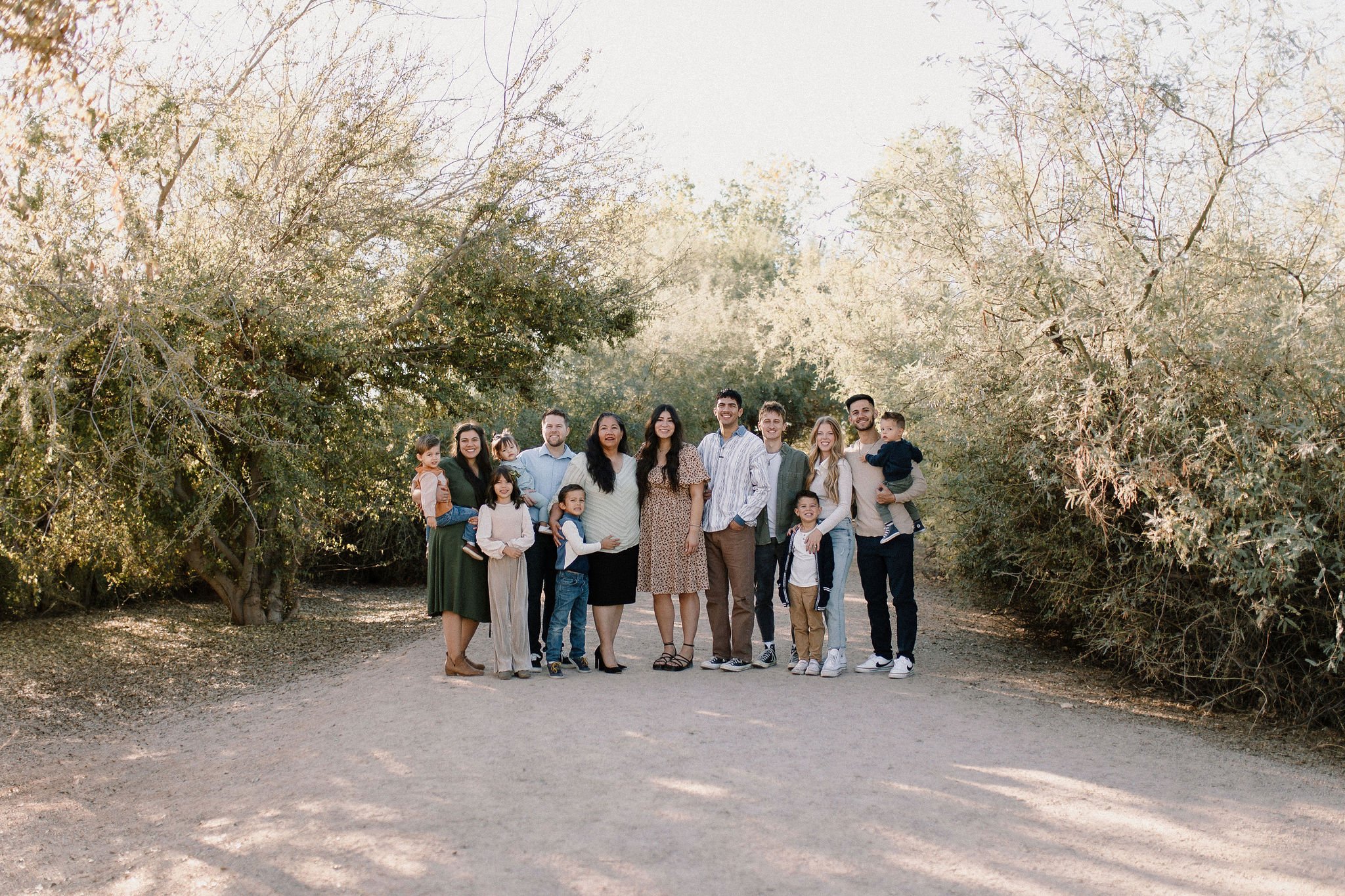 extended family standing together smiling in desert greenery family photography session in Gilbert, Arizona