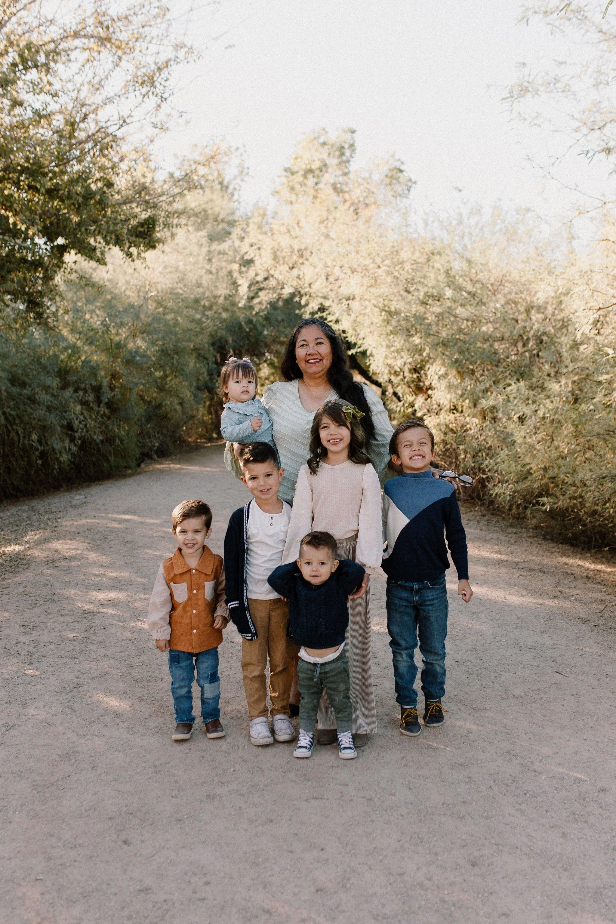 grandma standing with grandkids smiling during extended family photography session n Gilbert, Arizona