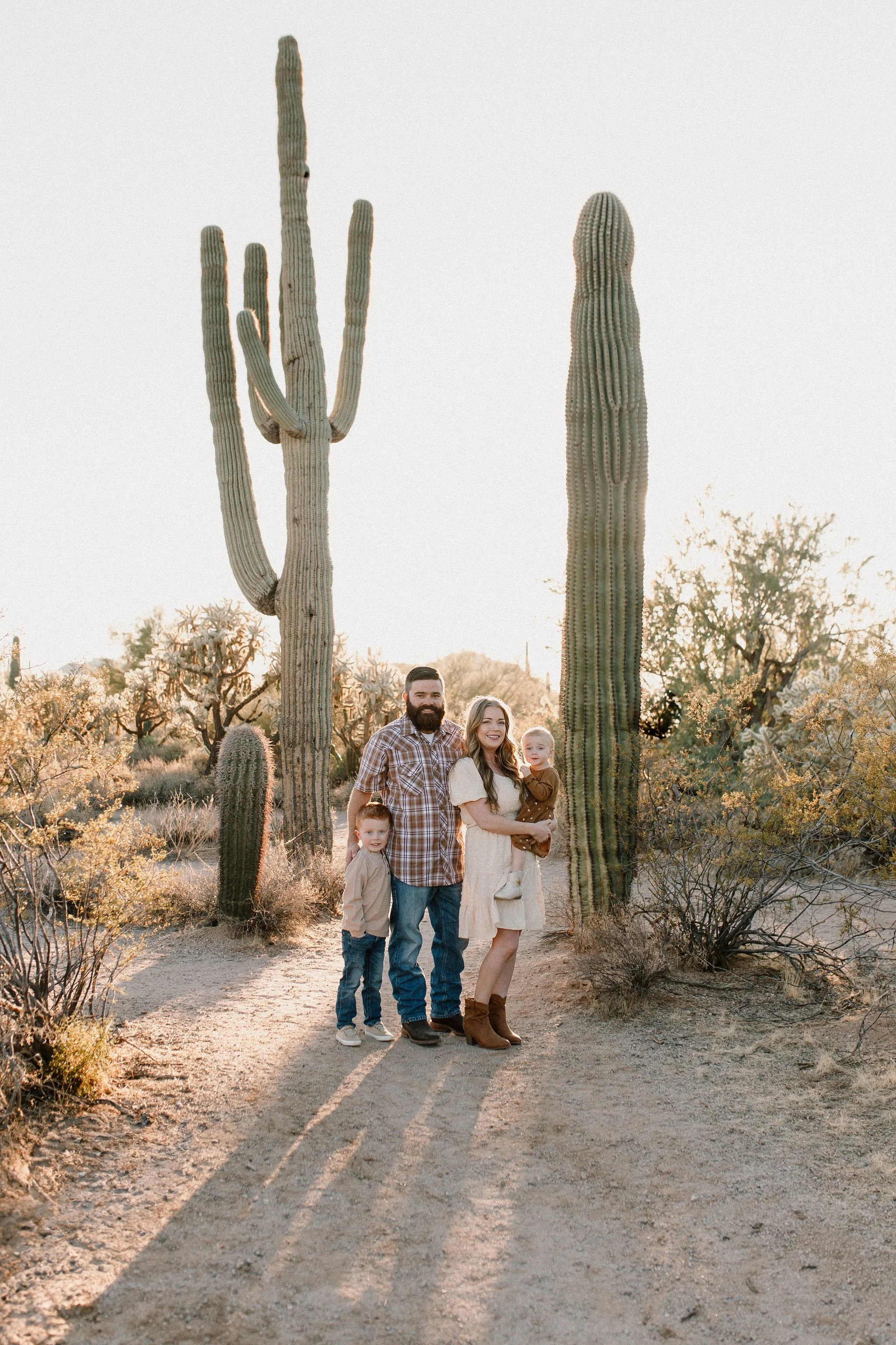 family of four standing together smiling in desert family session at Usery Mountain in Arizona