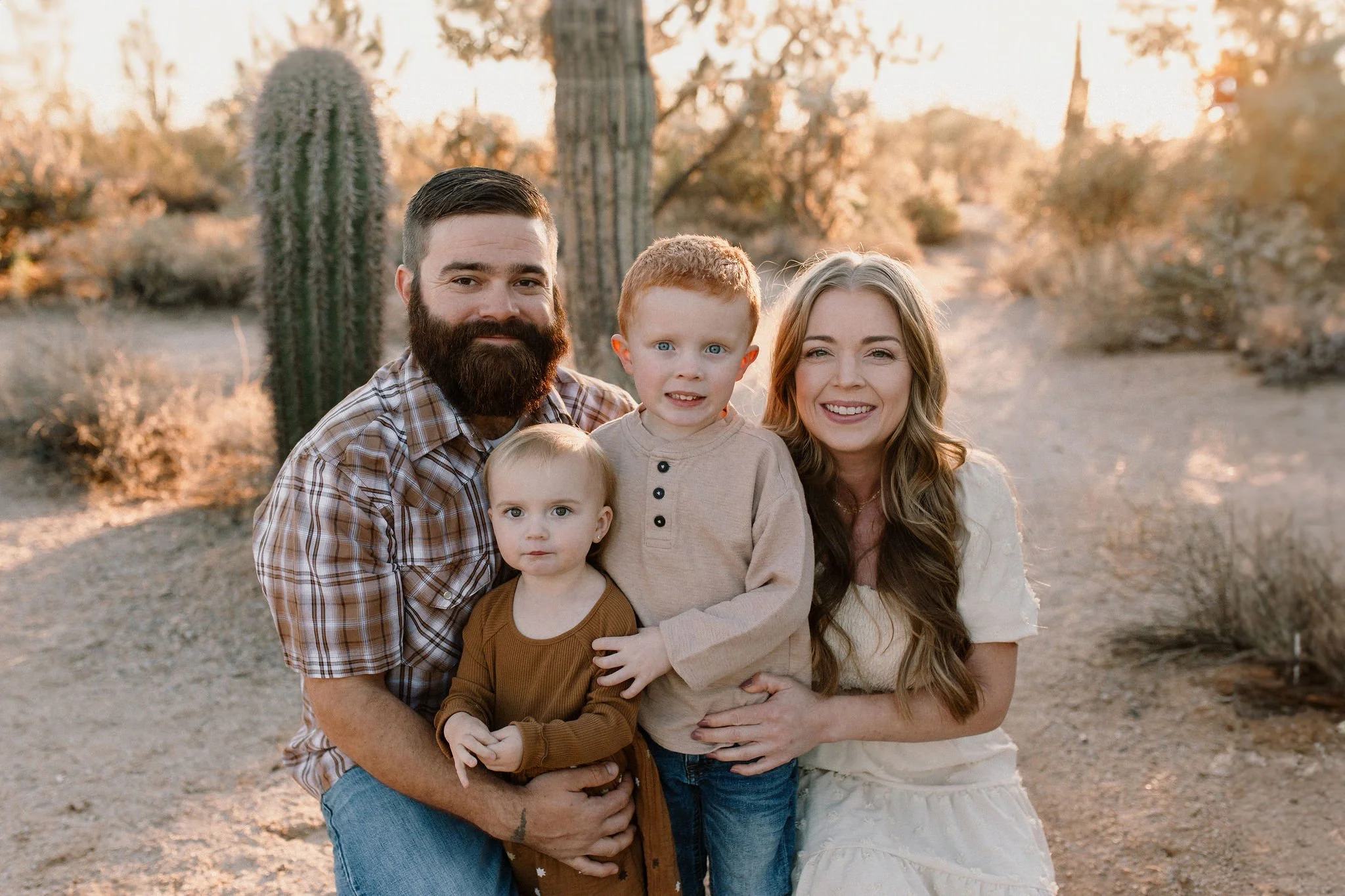 family of four standing together smiling in desert family session at Usery Mountain in Arizona