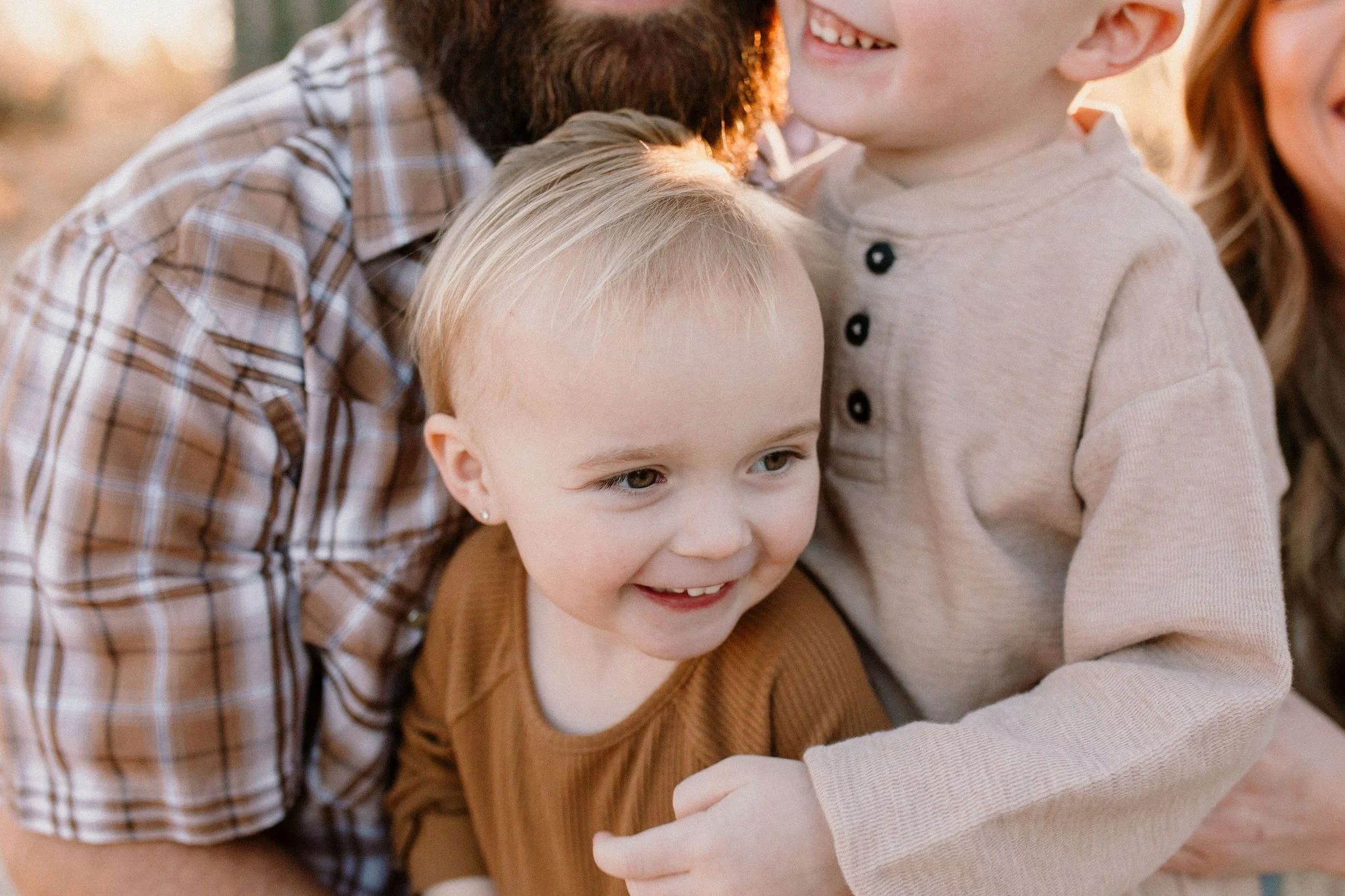 close up of toddler smiling and laughing with family in desert family photography session