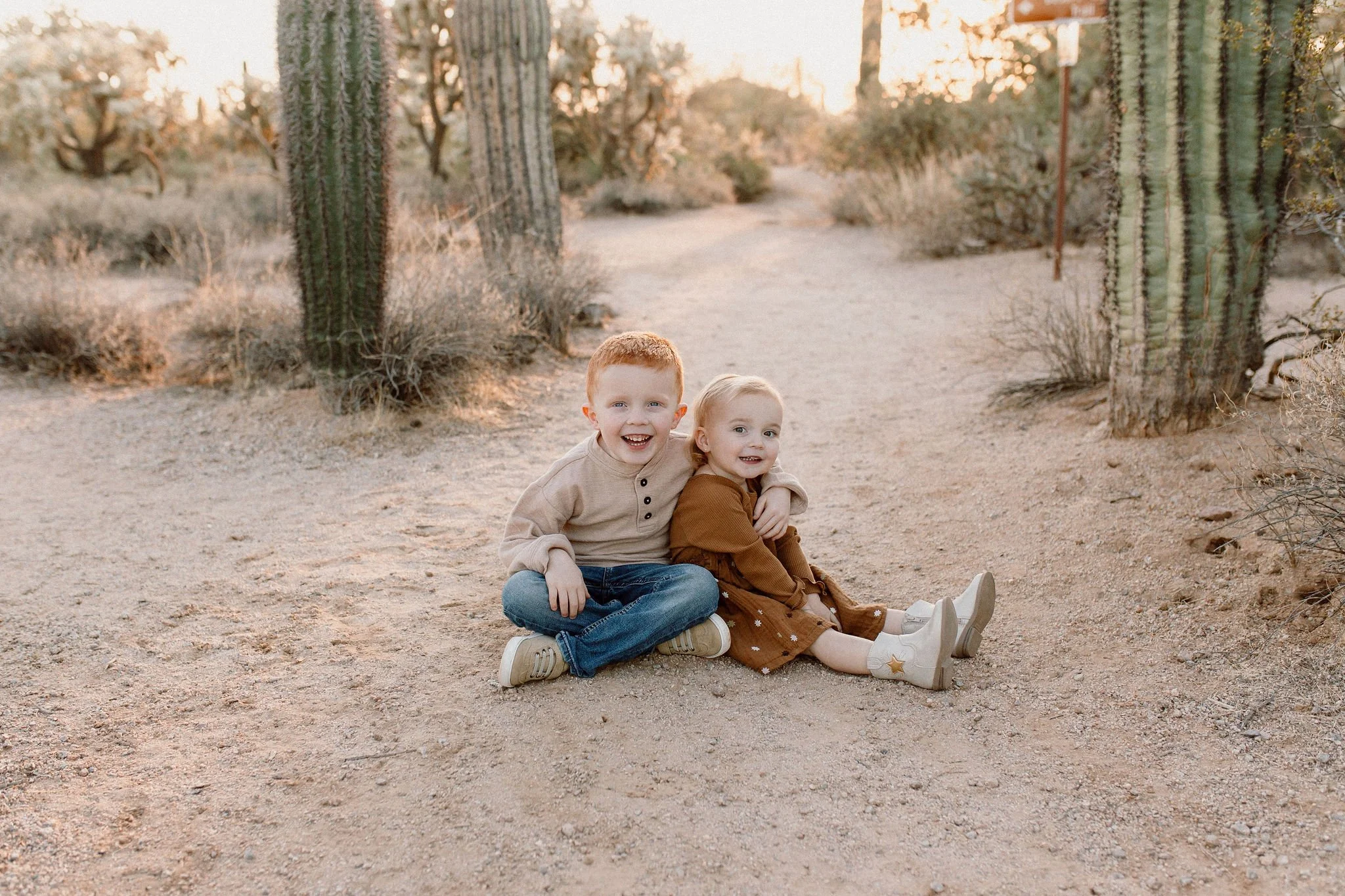 siblings sitting together and smiling during family photography session