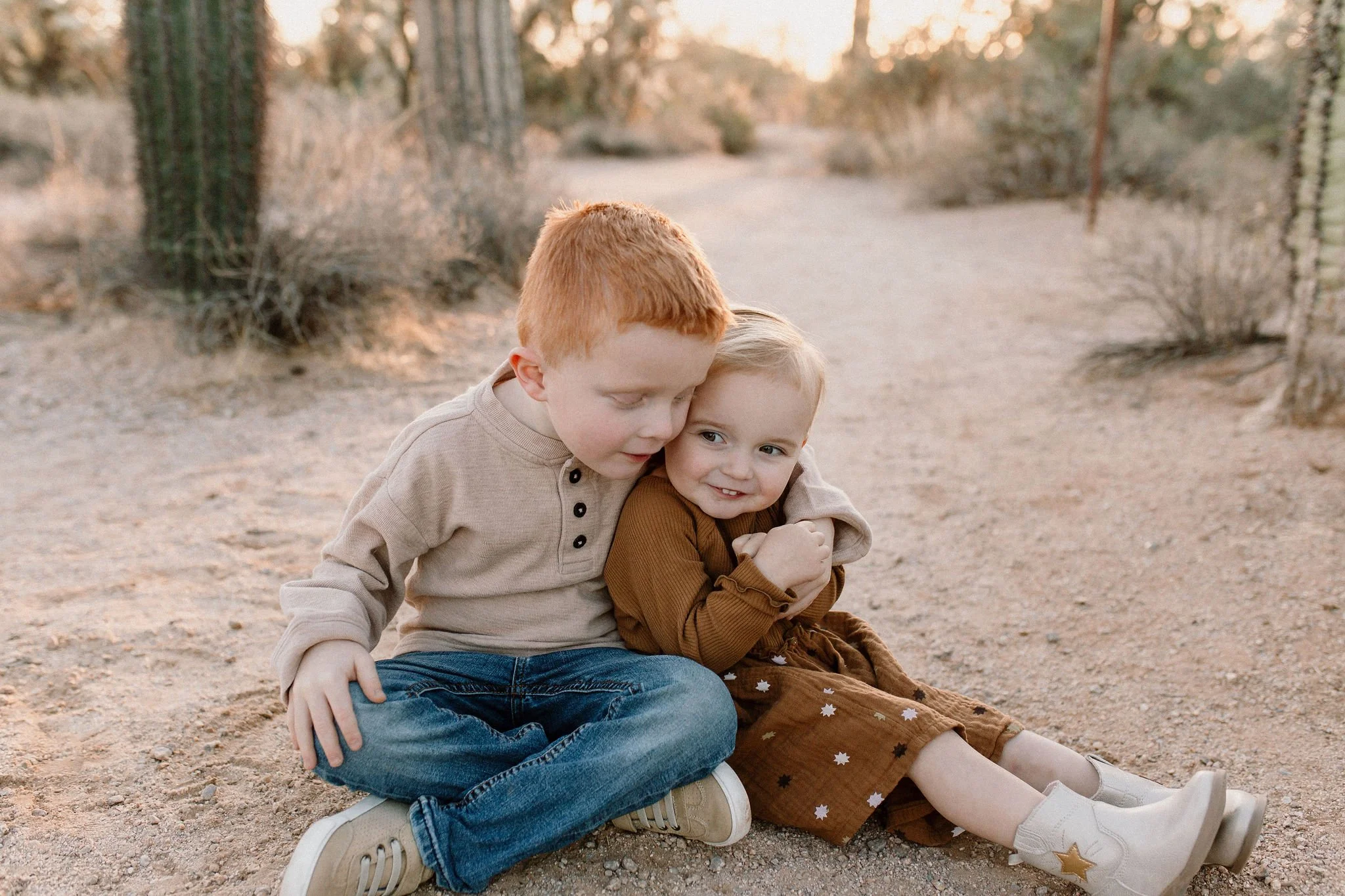 siblings sitting and hugging in desert family photography session