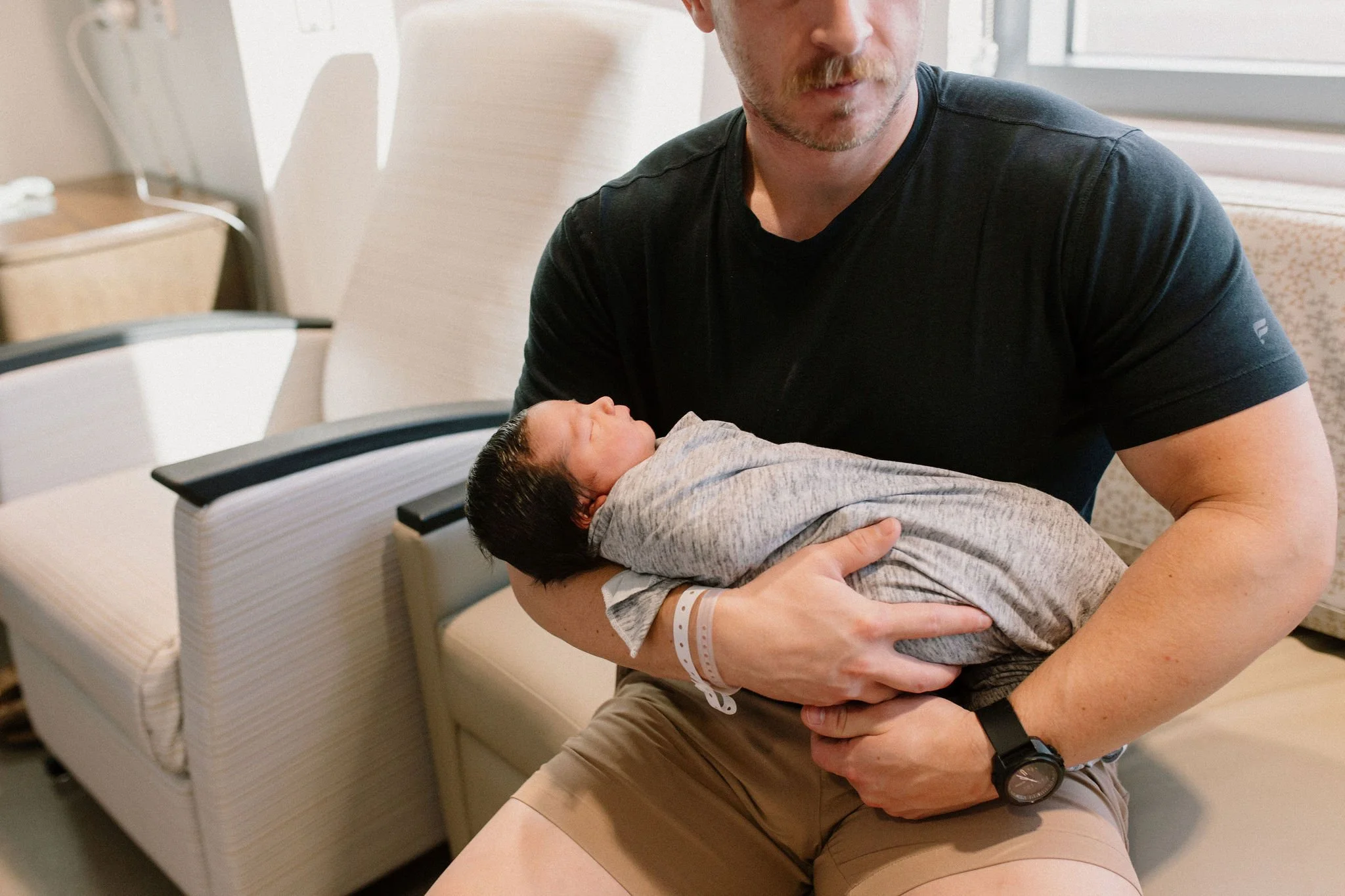 dad holding swaddled newborn baby in hospital by Mesa fresh 48 photographer