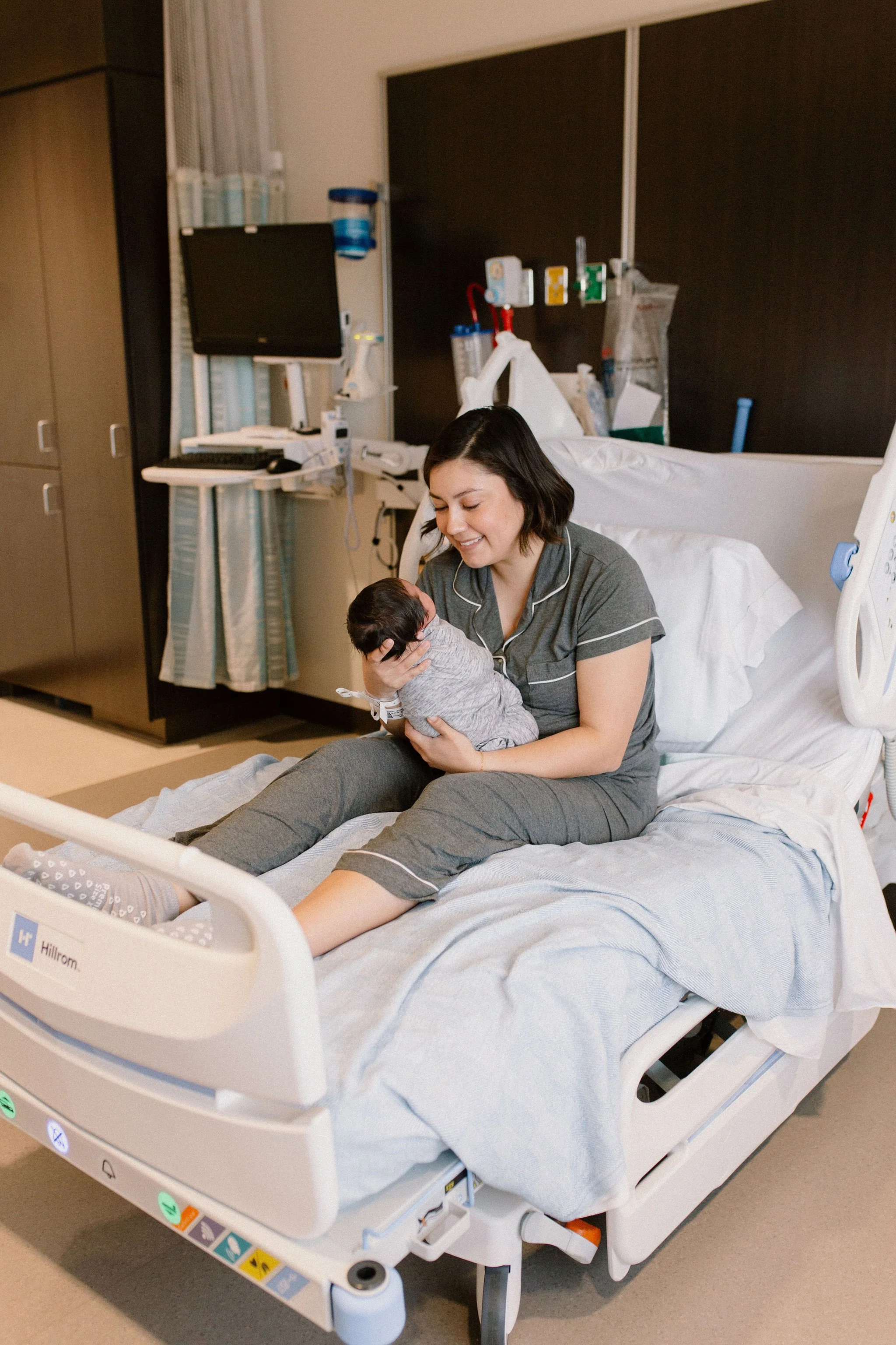 mom holding newborn baby in hospital bed captured by Mesa fresh 48 photographer