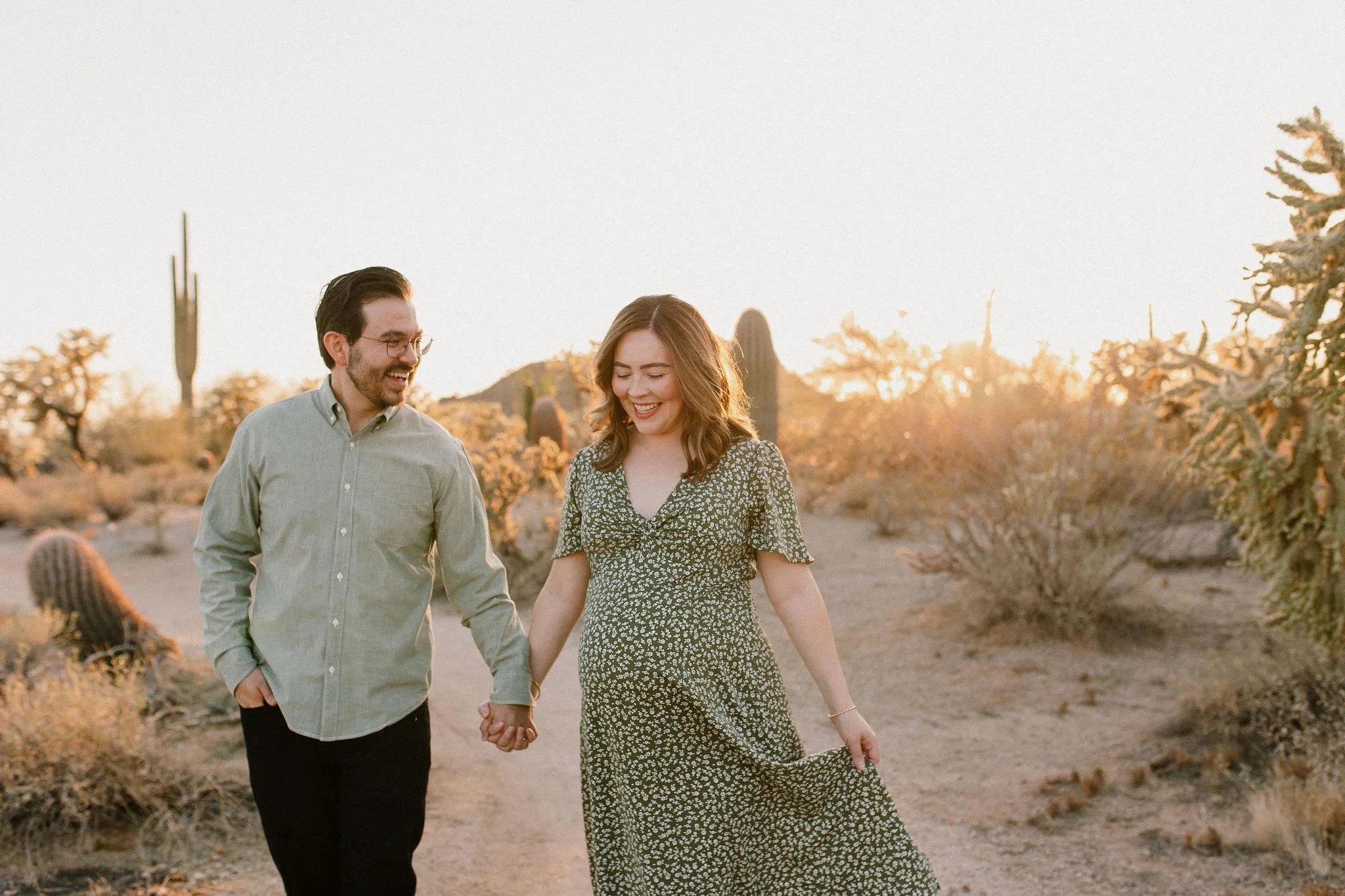 pregnant mom walking holding dad's hand in golden hour maternity photoshoot in Gilbert, Arizona