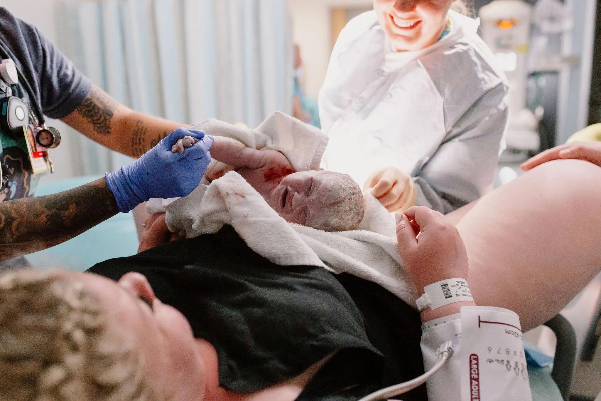 newborn baby placed on mom immediately after delivery by mesa birth photographer