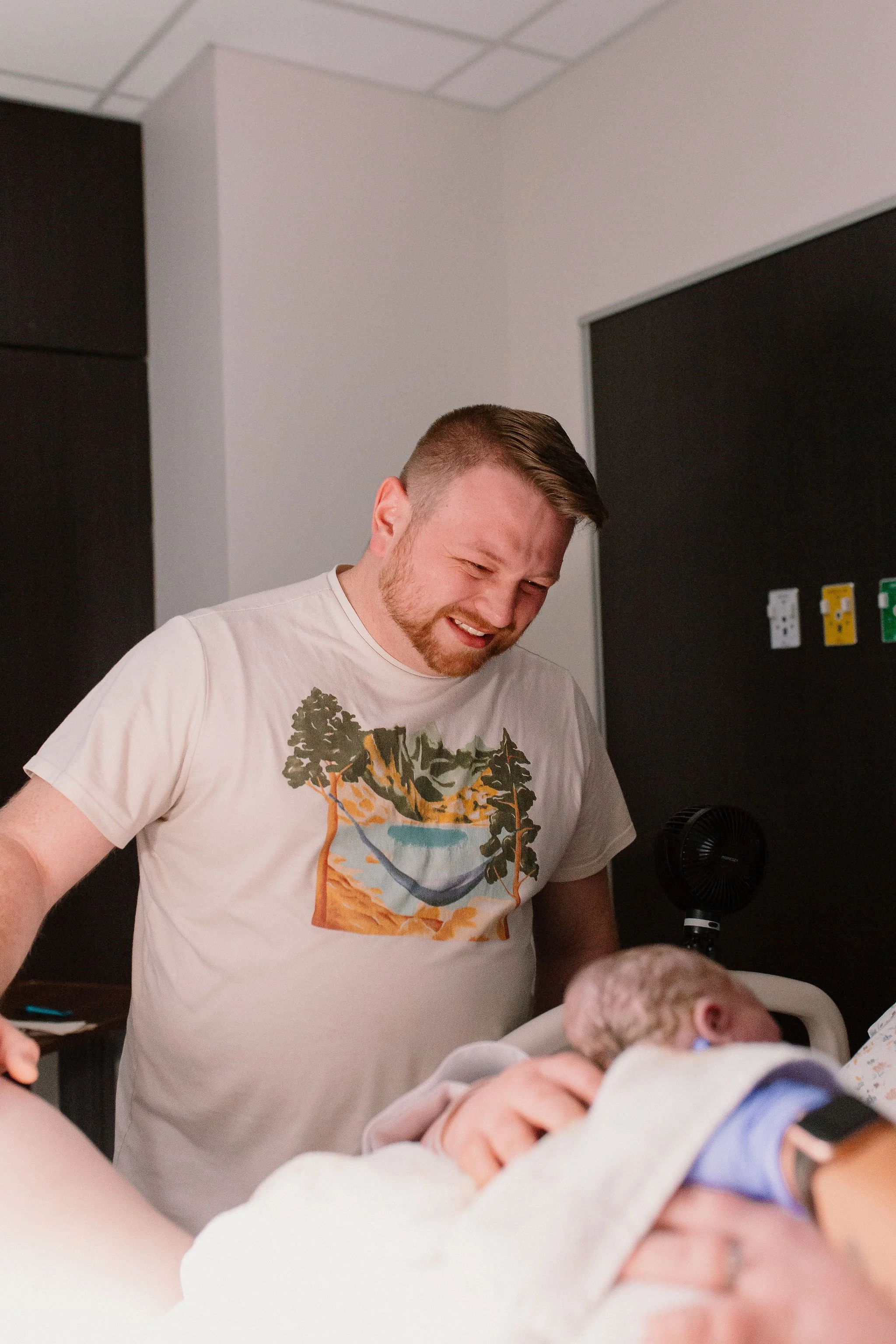 dad watching newborn baby being born captured by Mesa birth photographer