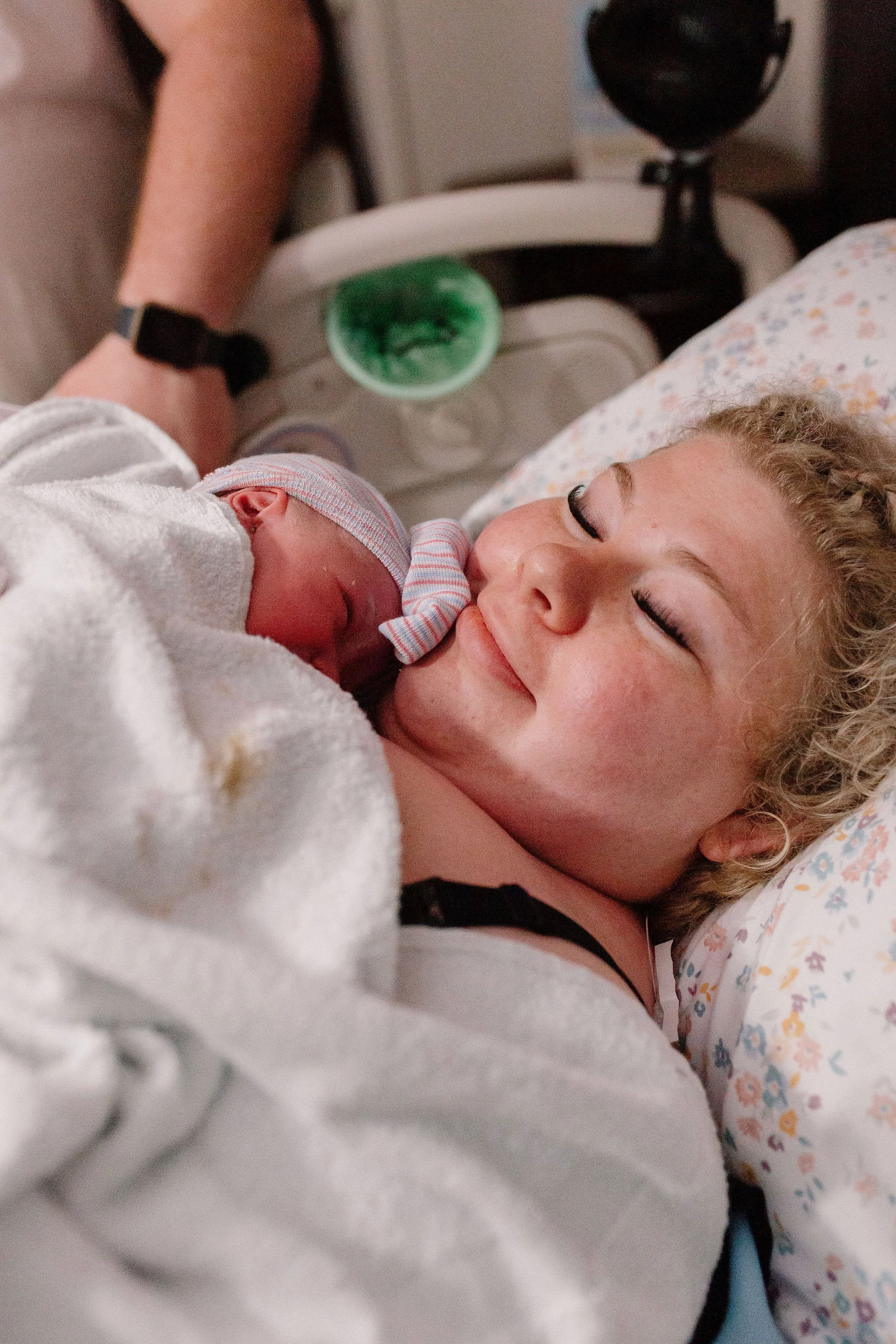 mom holding newborn baby immediately after delivery by Mesa birth photographer