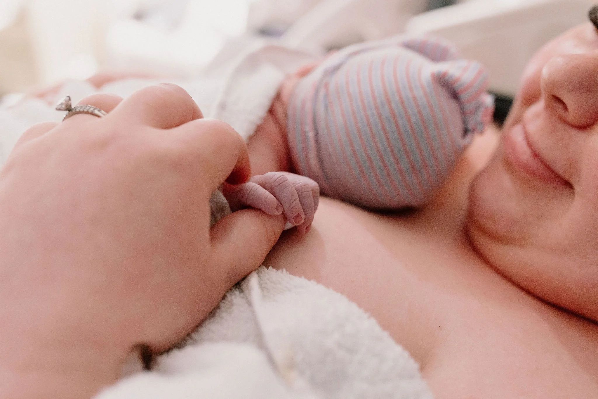 close-up detail of newborn baby holding mom's finger captured by Mesa birth photographer