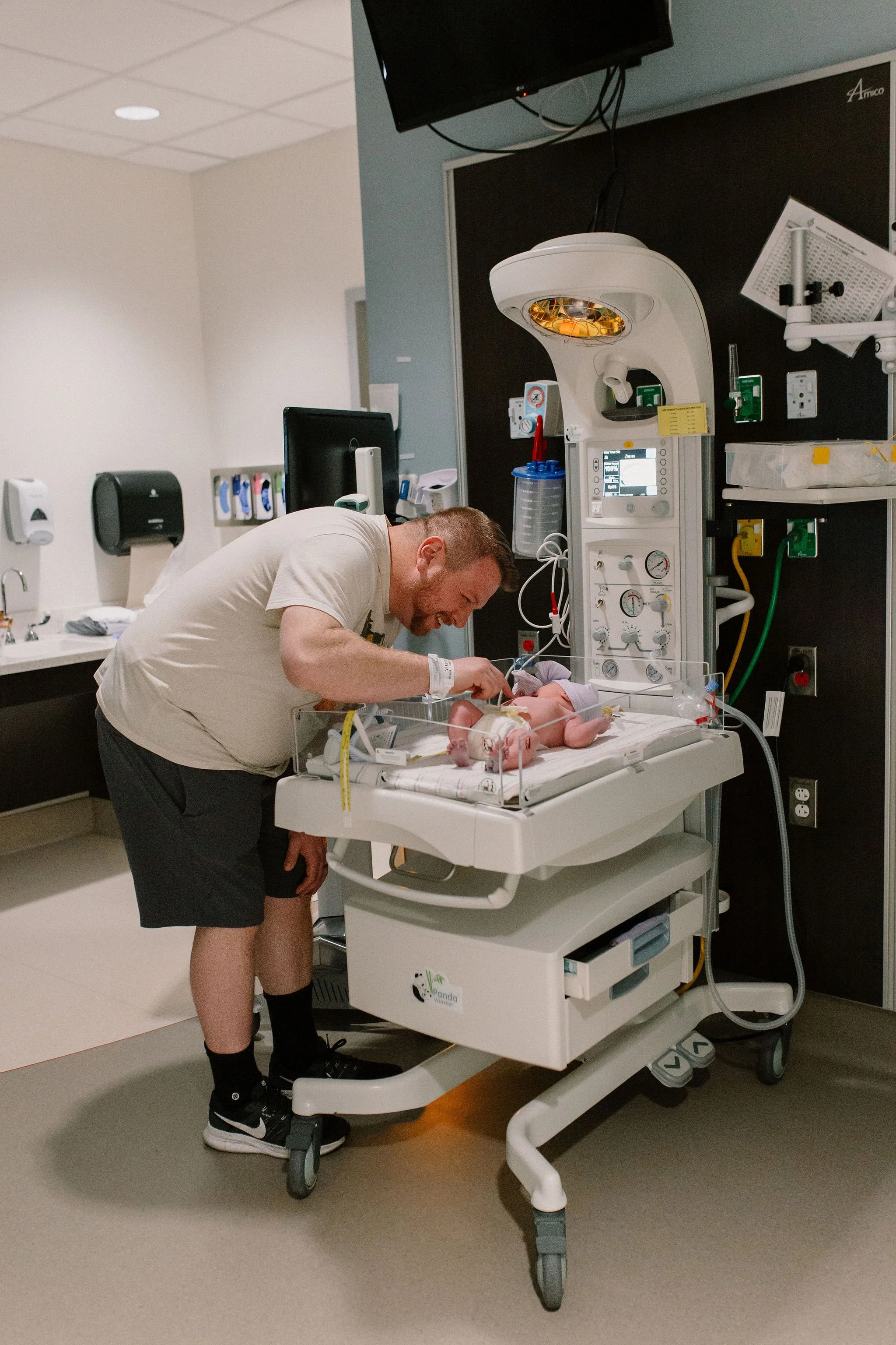 dad with newborn baby in warmer by Mesa newborn photographer