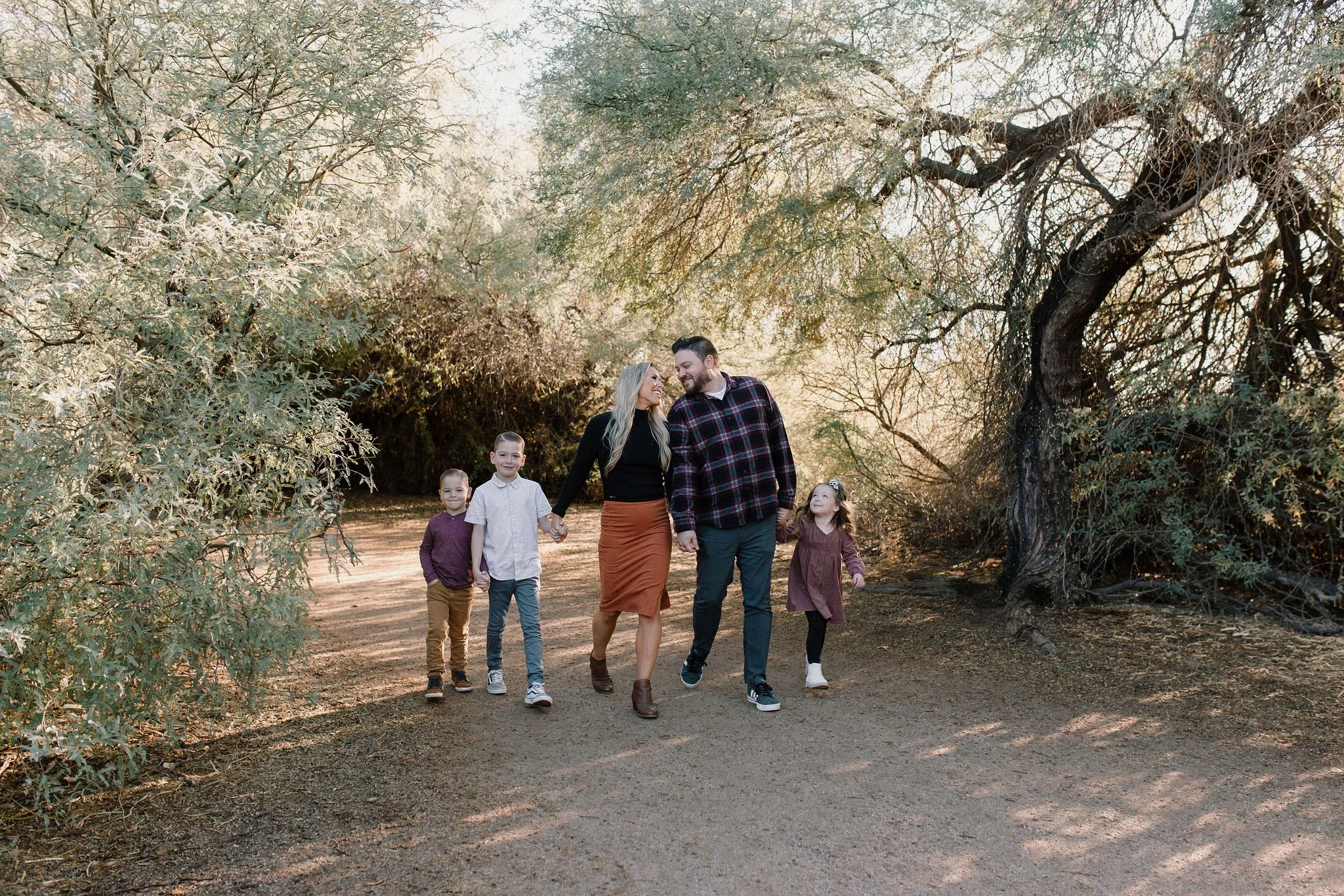 family walking together and holding hands at Gilbert Riparian Preserve in Arizona during family photo session