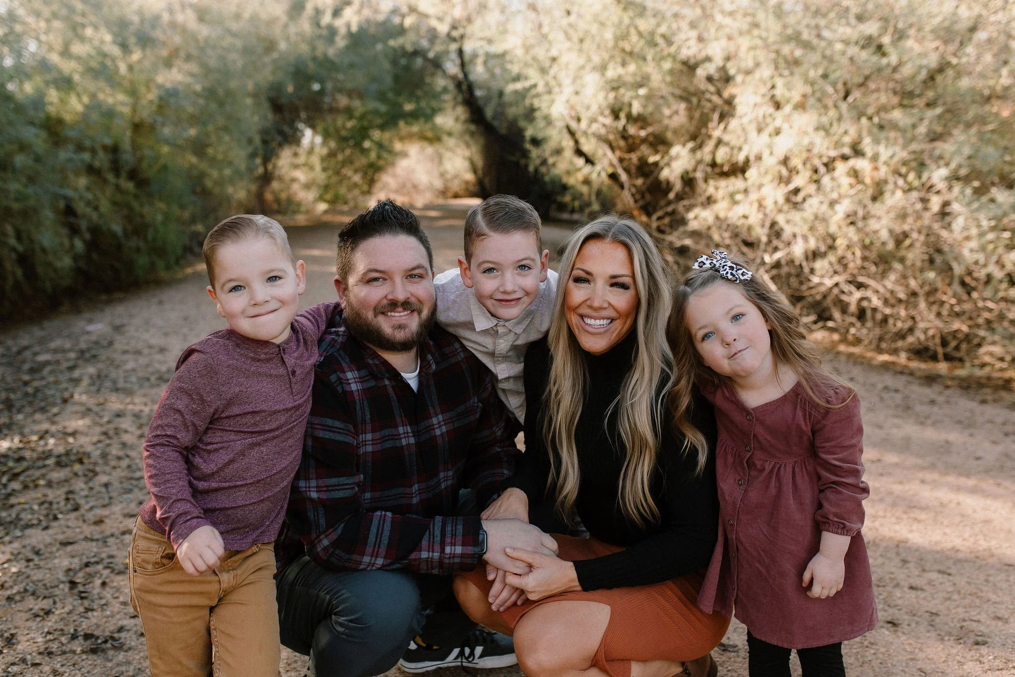 family of five smiling during family photos at Gilbert Riparian Preserve in Arizona