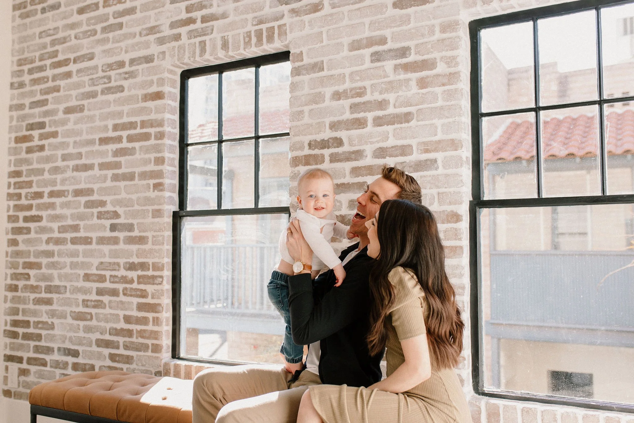 mom and dad making baby boy smile in neutral brick studio space in Phoenix, Arizona