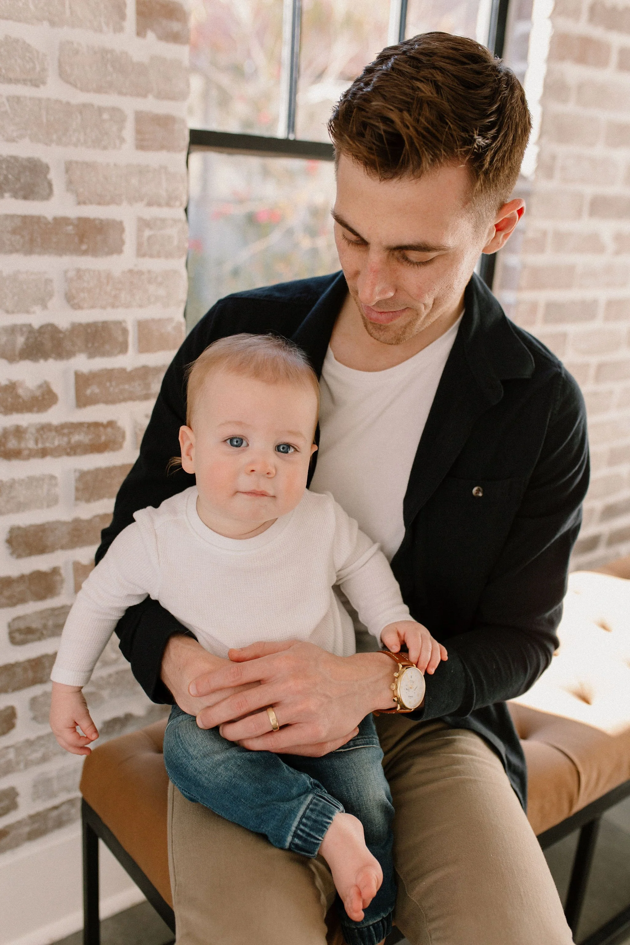 father and son sitting together in neutral studio family session in Phoenix, Arizona