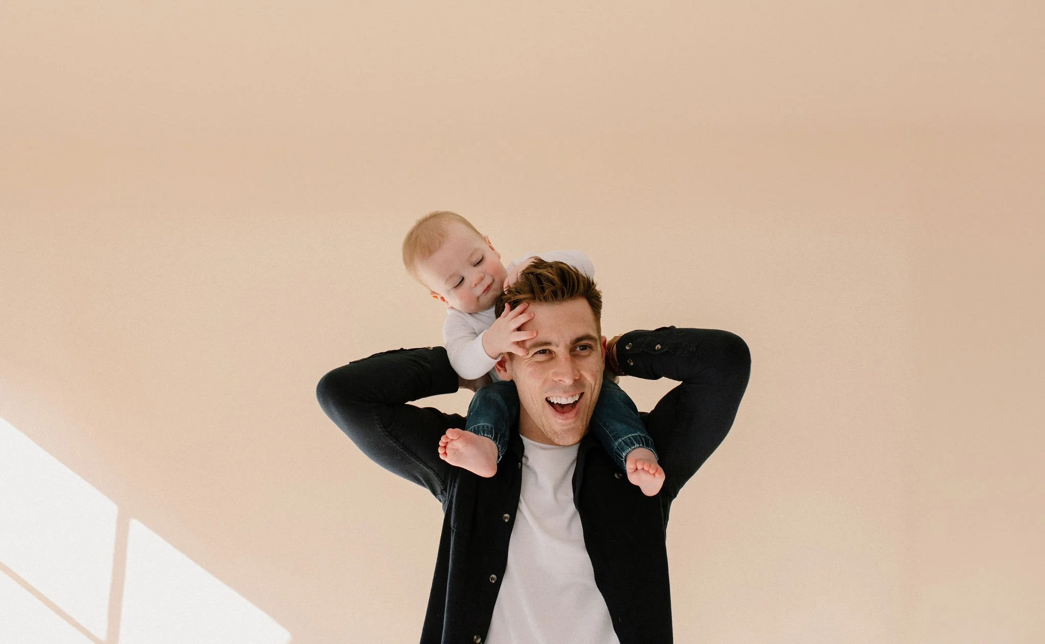 baby boy on dad's shoulders in neutral studio in Phoenix, Arizona