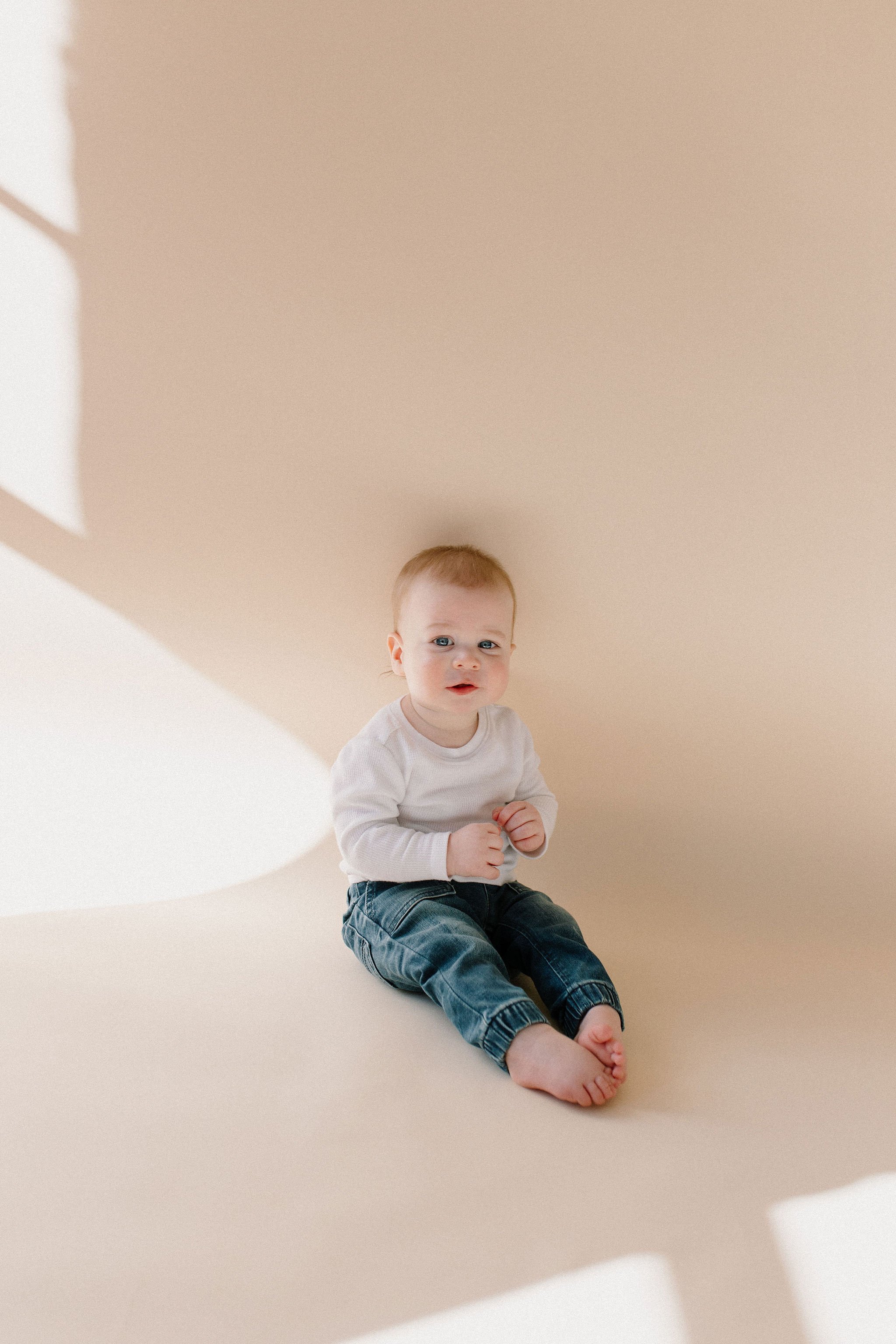 baby boy sitting in neutral studio family session in Phoenix, Arizona