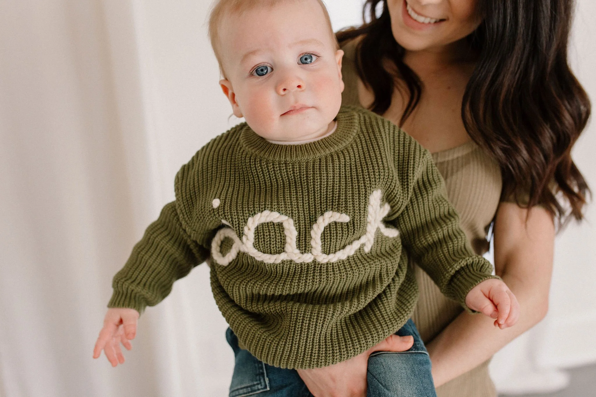 mom holding baby boy in neutral studio family session in Phoenix, Arizona